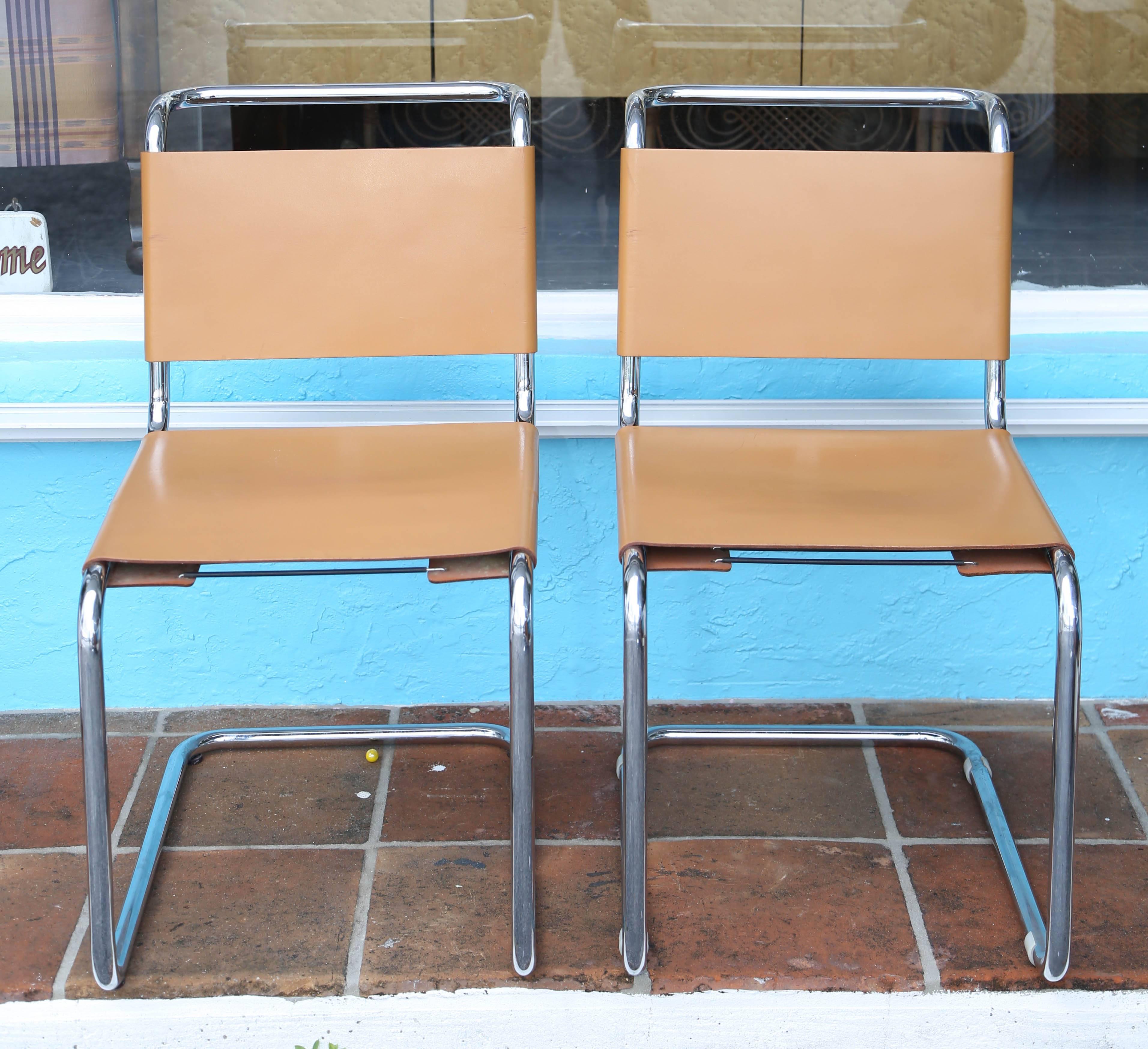 Classic Bauhaus Industrial age aesthetic of cantilevered tabular steel (chrome-plated) with laced leather backrest.
The pair of chairs are appointed with camel colored leather. An additional pair is available with
reddish brown leather seats and