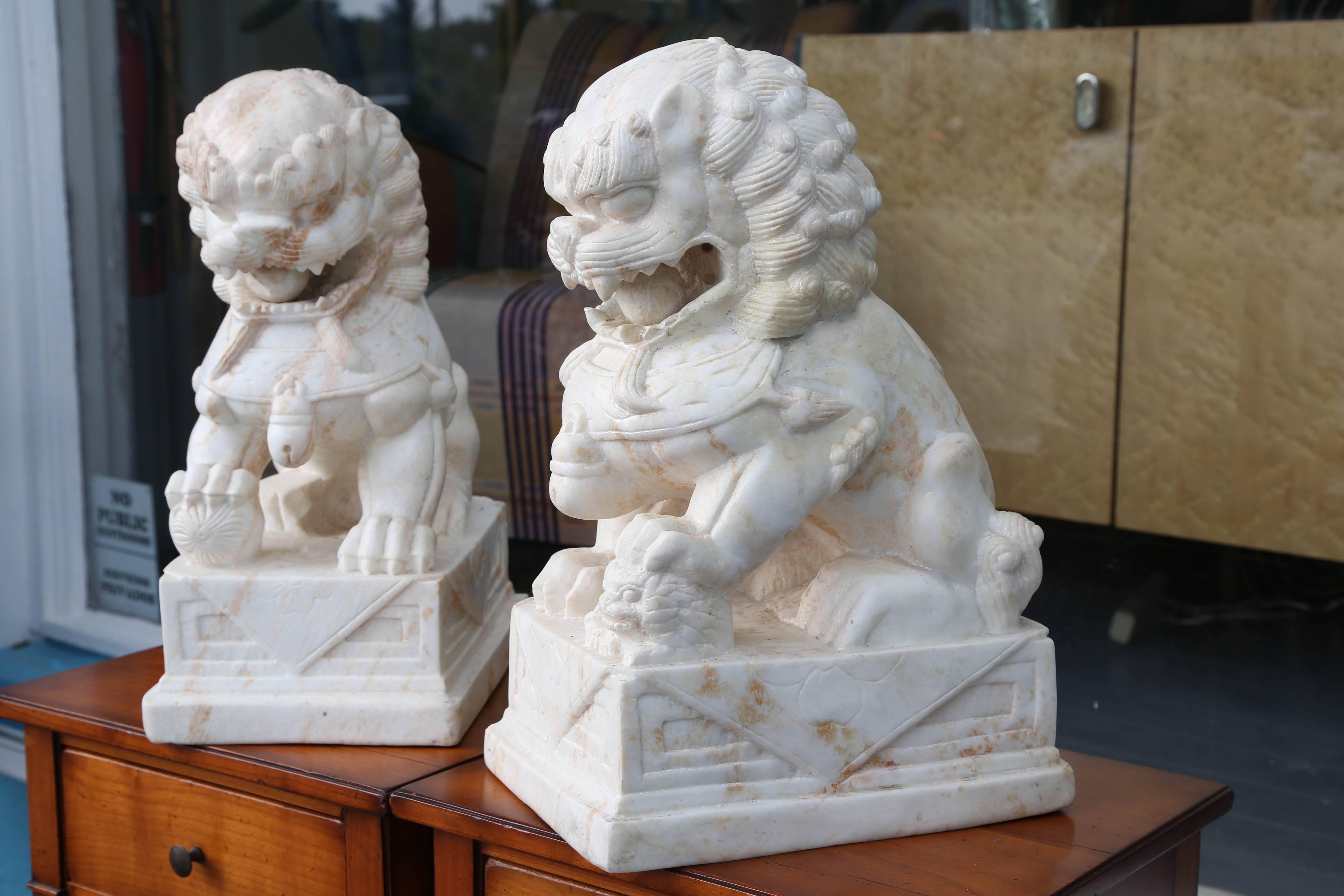 A hand-carved pair with excellent detail. Each figure is carved with a moveable ball in its 