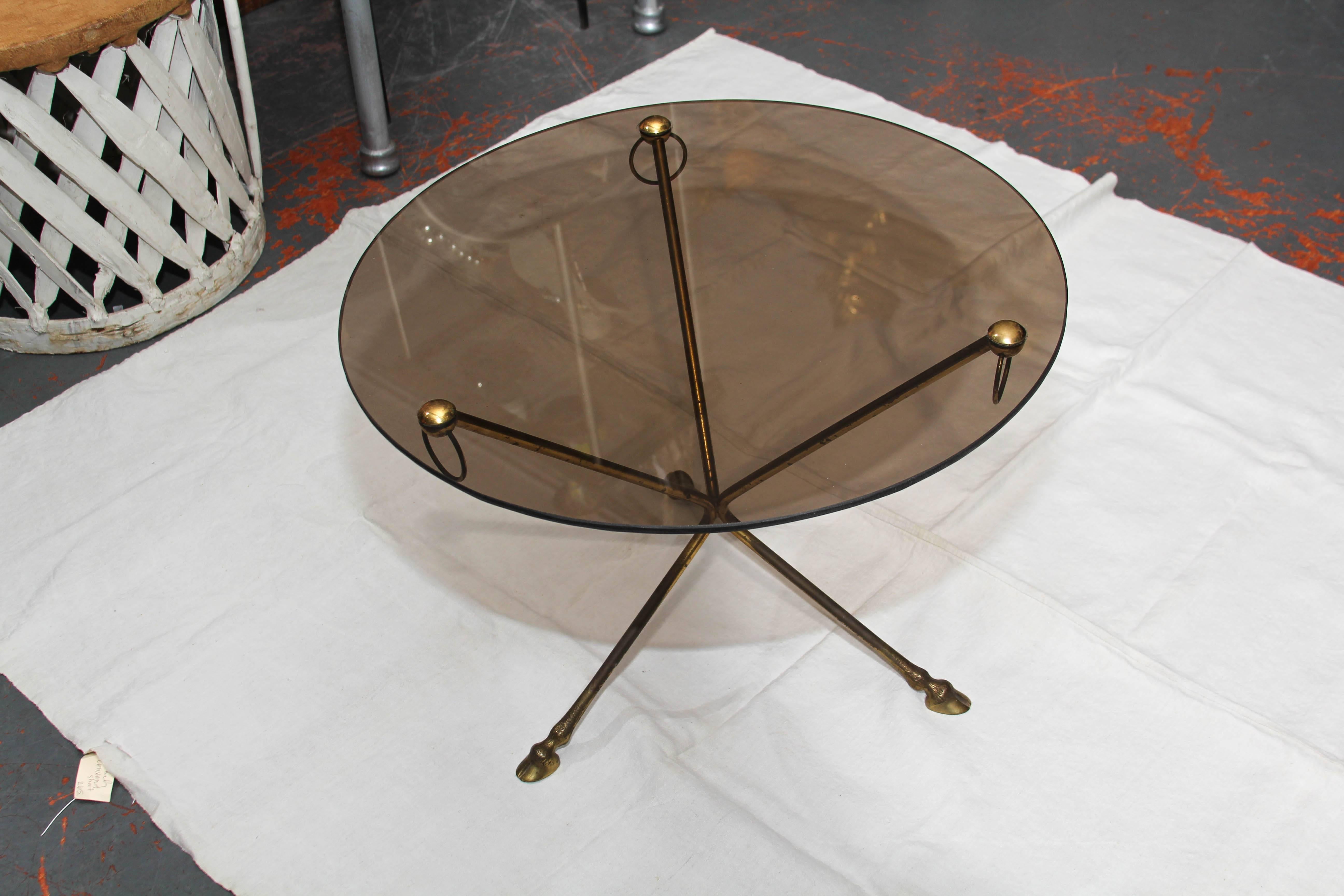 Diminutive  French smoke-glass and patinated brass side table / smoking table with a tripod base, decorative brass ring accents and exquisite deer hoof feet.  