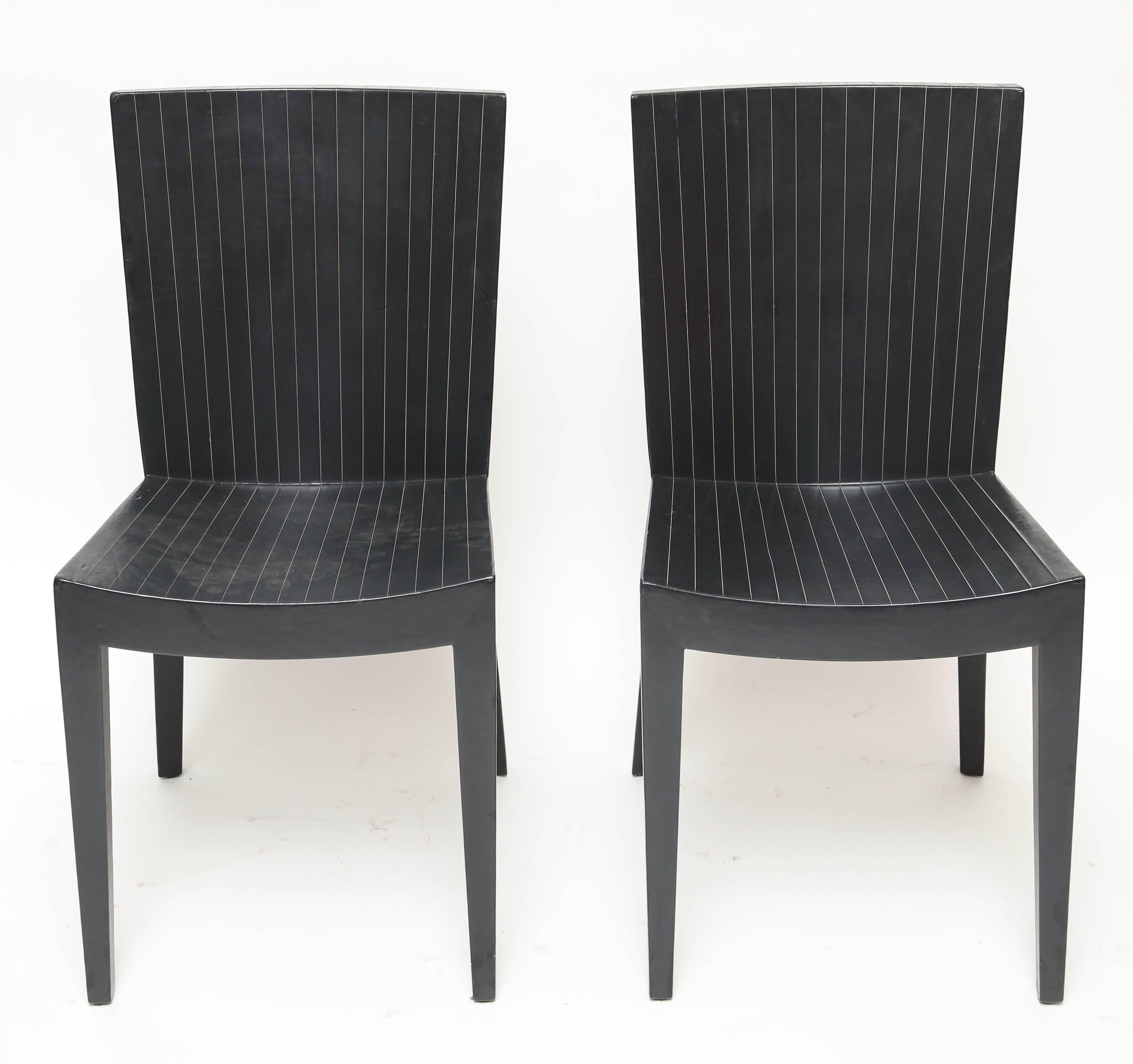An elegant pair of chairs covered in scored midnight blue leather
price is for both chairs.