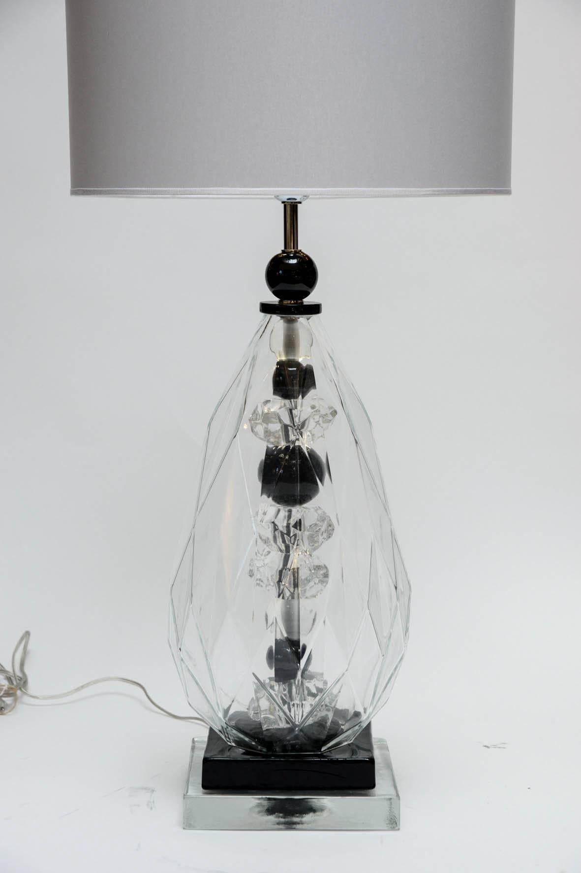 Pair of table lamps made of different pieces of transparent and black tinted Murano glass, caged in a larger drop shaped piece.