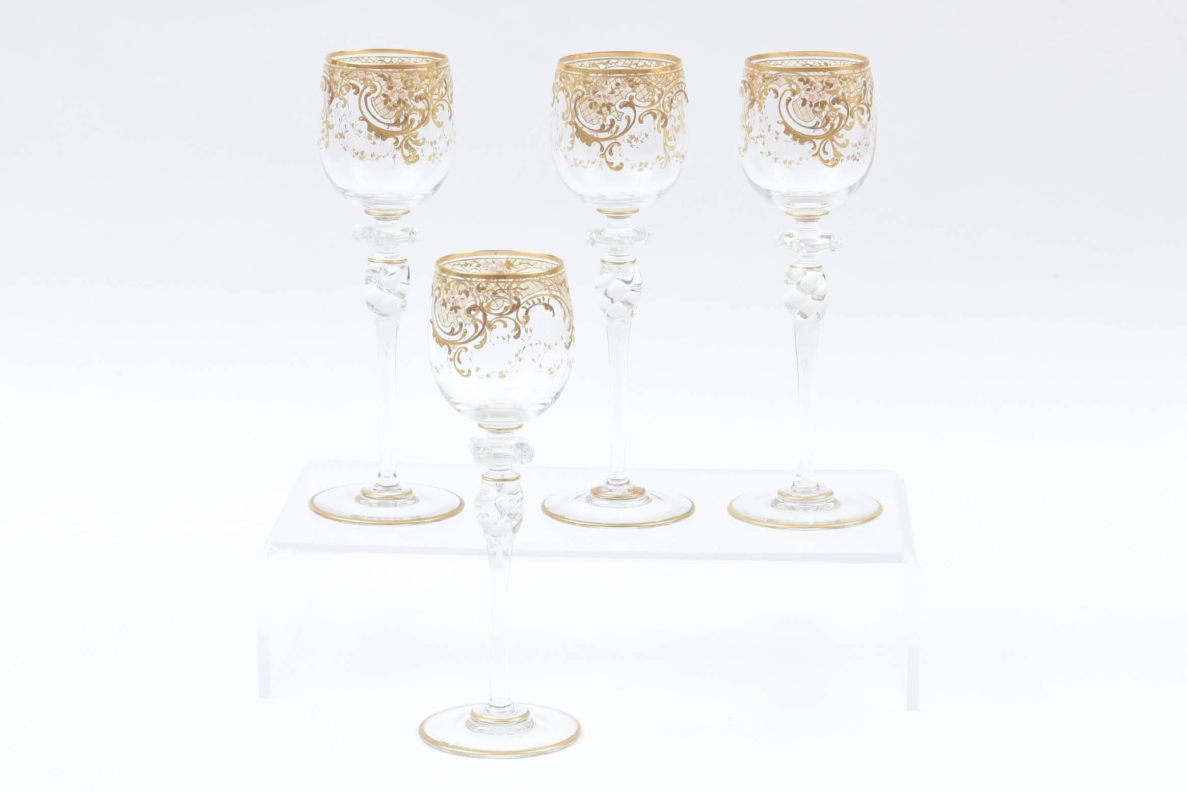 A pretty set of blown wine glasses with some great detail. Extra applied glass prunts, raised tooled gold and hand enameled flowers surround the bowl. A nice tall swirl stem and trimmed on the bottom with gold too.