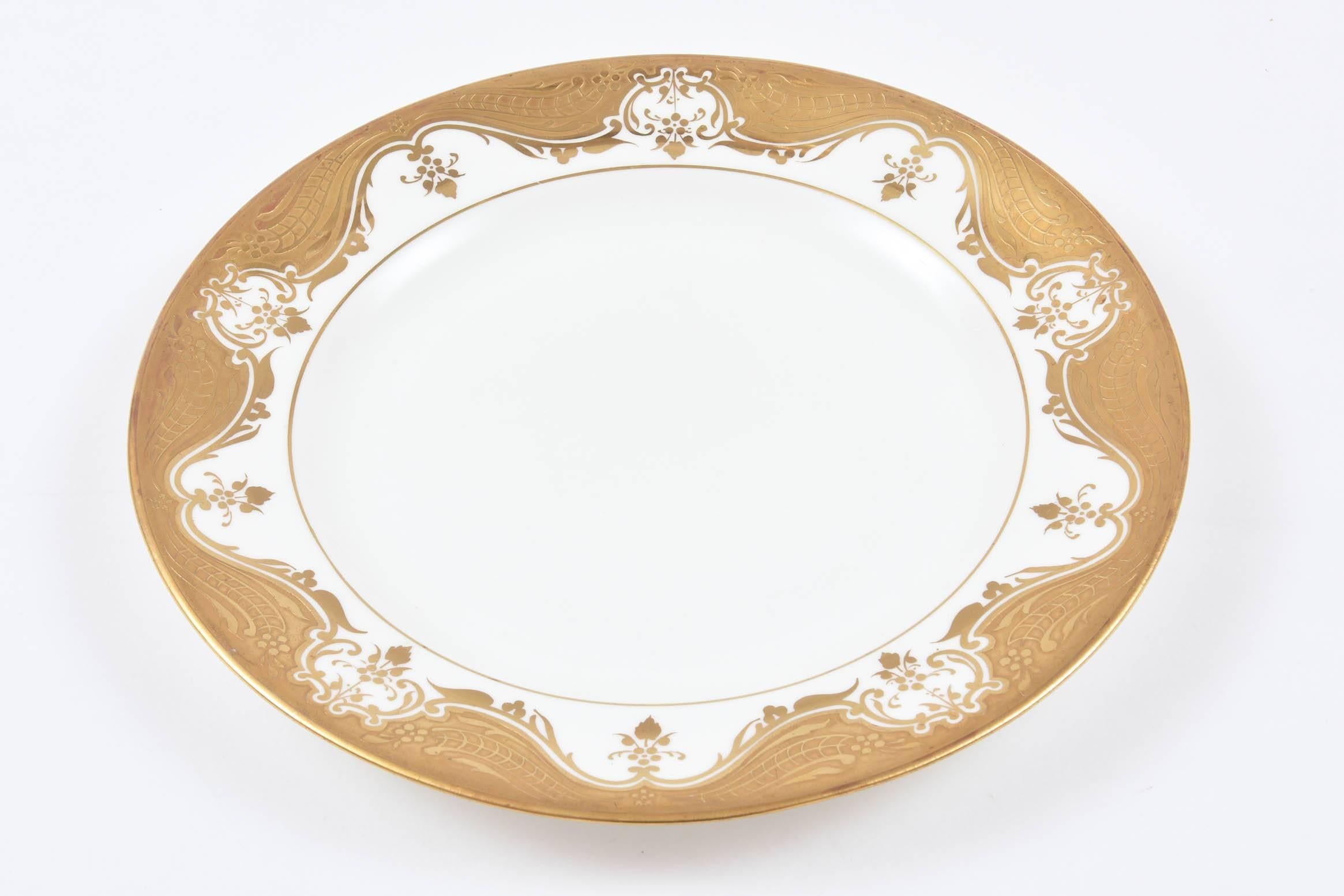 An unique and lovely set of 12 white and classic gold etch band plates measuring just under 10.0