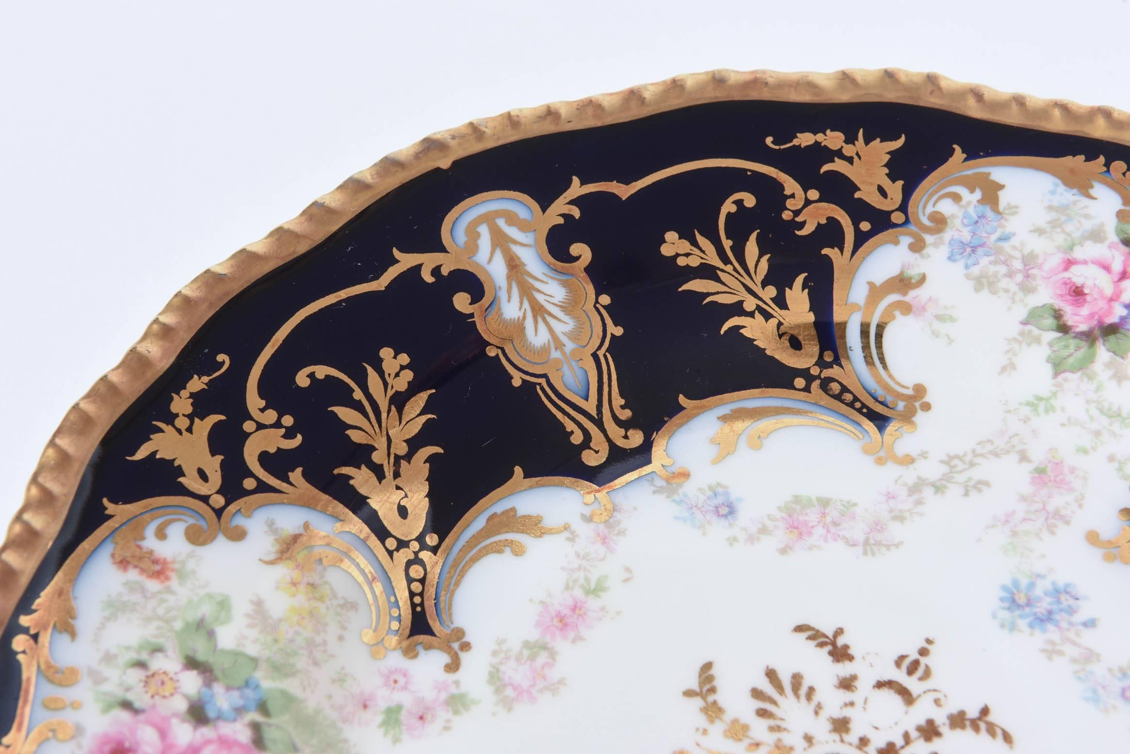 We love the scalloped shape and nice gadroon edging to these handsomely painted plates. There is a delightful centre gilt medallion and the design features elaborate cartouches in the cobalt blue shoulders revealing nicely hand-painted floral