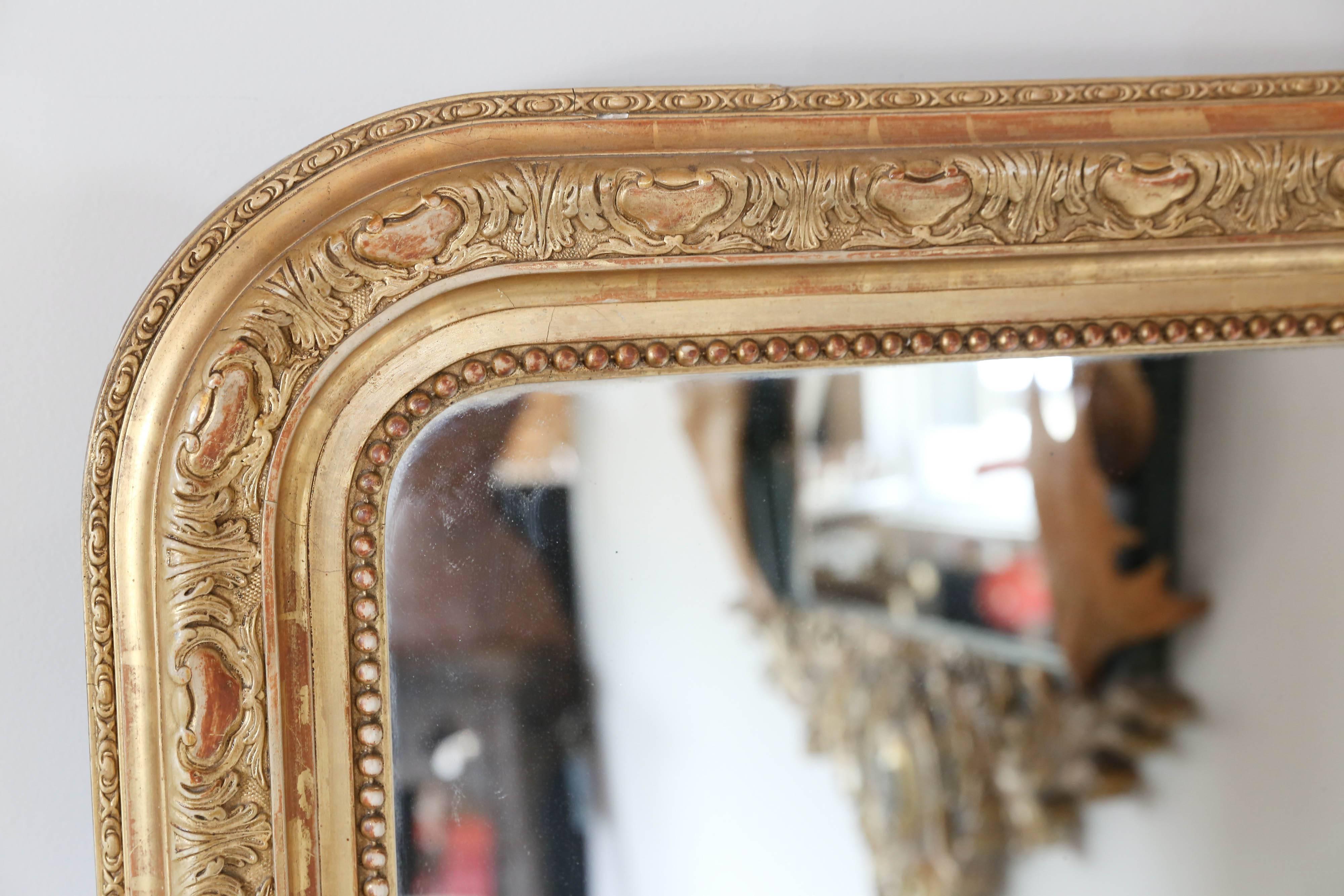 This antique Louis Philippe mirror features beautiful art nouveau carvings around the frame. the mirror is in very good condition and this piece does have a covered back. See images for full details. 

Measures 37.5
