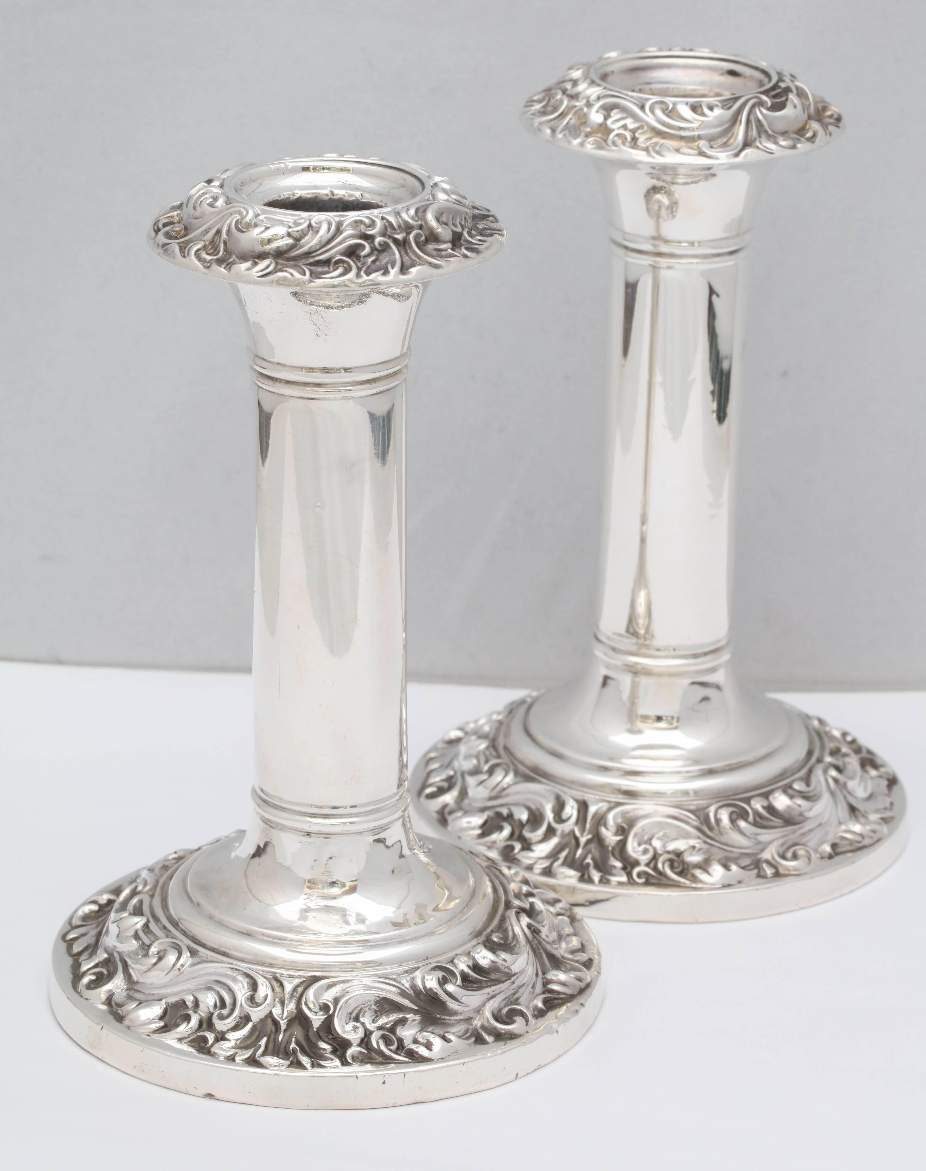 Pair of Edwardian, sterling silver candlesticks, Birmingham, England, 1906, E.L.G. - maker. Measures: 6 1/2 inches high x a little over 4 inches in diameter across the base of each. Underside of base is wood. Pretty swirled design around edge of