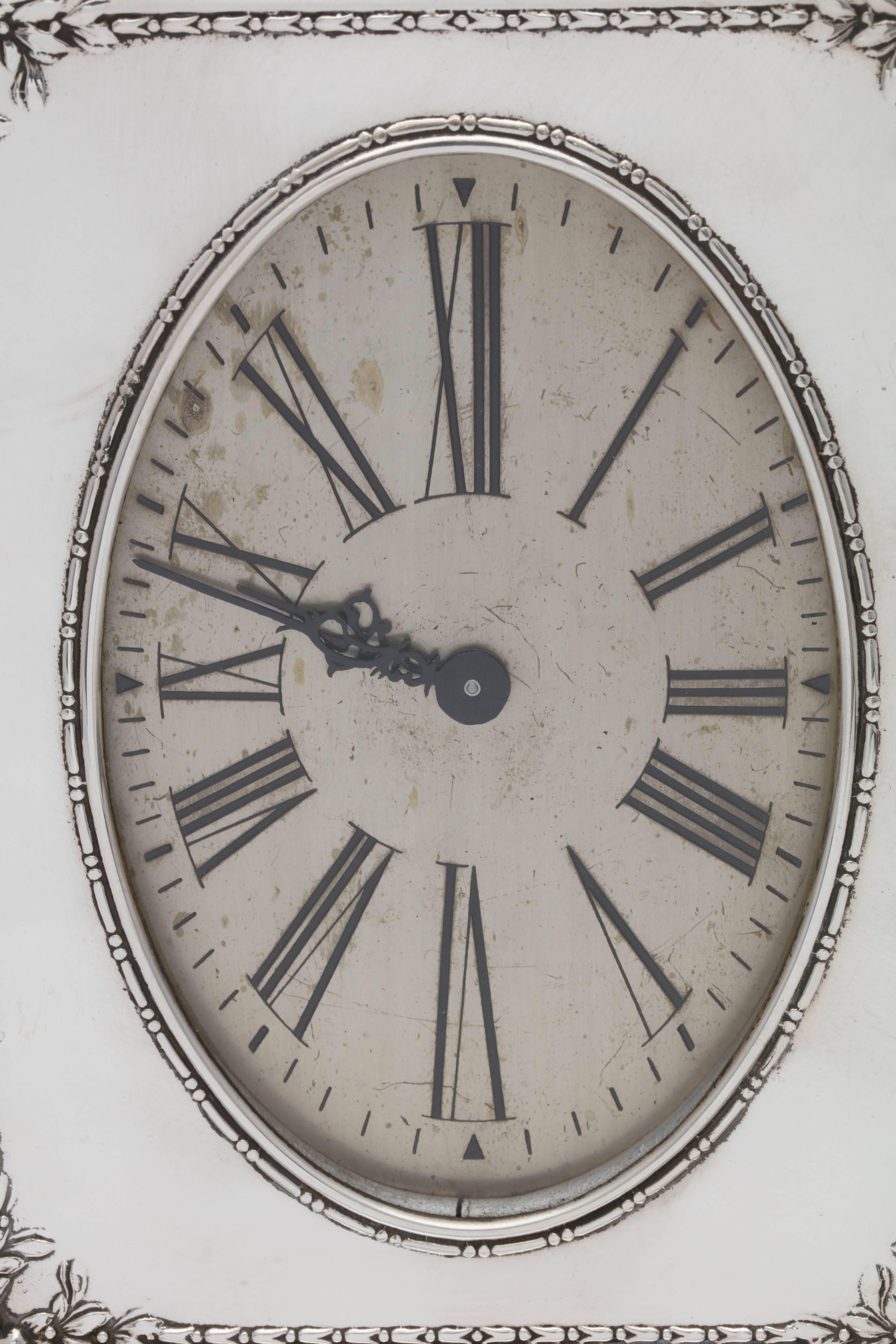 Edwardian, sterling silver, eight day table/mantel clock, Reed and Barton (movement is by Waltham), Taunton, Mass., circa 1910. Measures: 7 1/2 inches high x 7 inches wide x 3 inches deep. Wood back. Winding stem is on underside of clock. Runs for