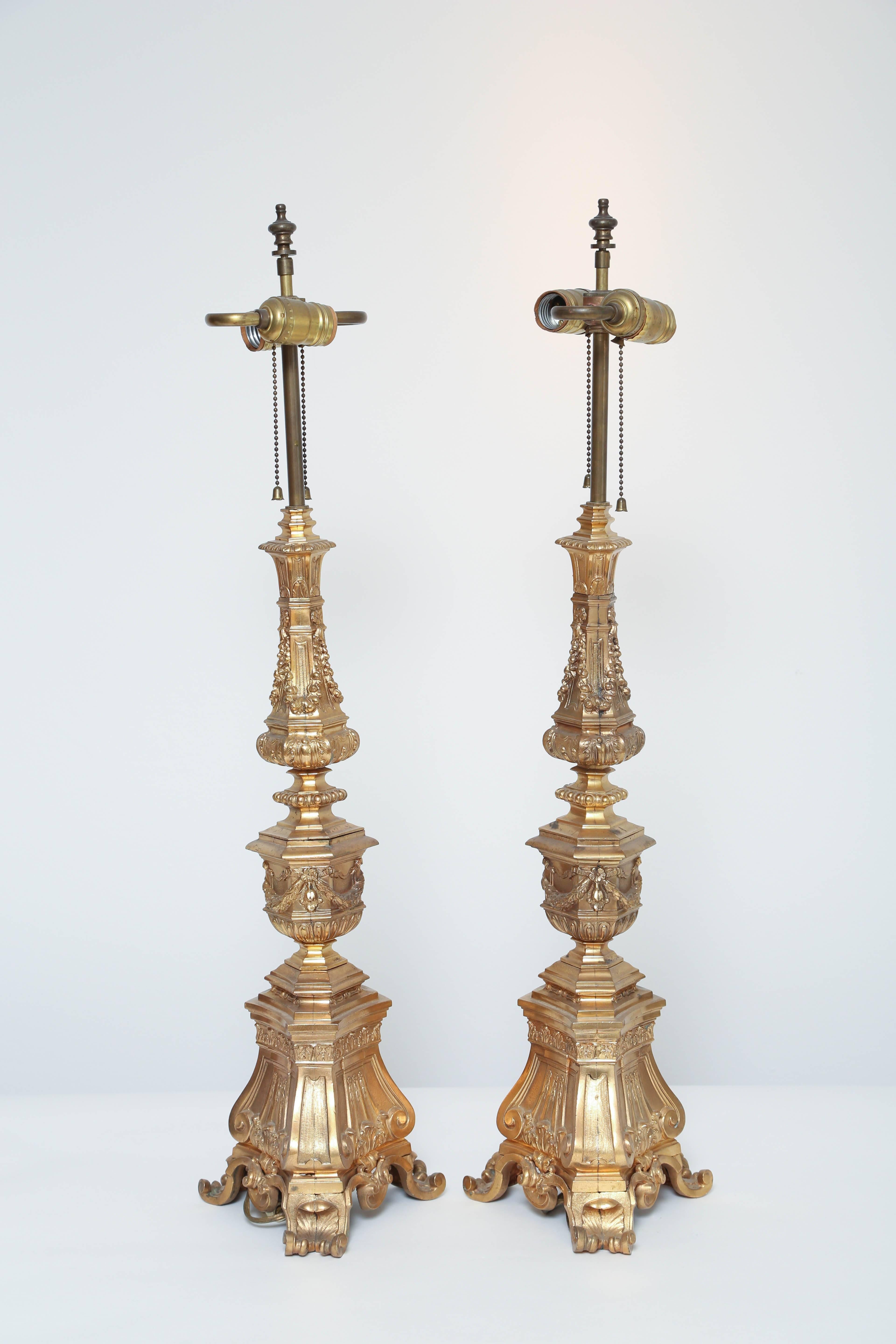 These large baroque style gilt bronze table lamps make a magnificent impression. They would be lovely with pastel silk lampshades.

Each is electrified with two sockets but rewiring is always recommended for older lamps.