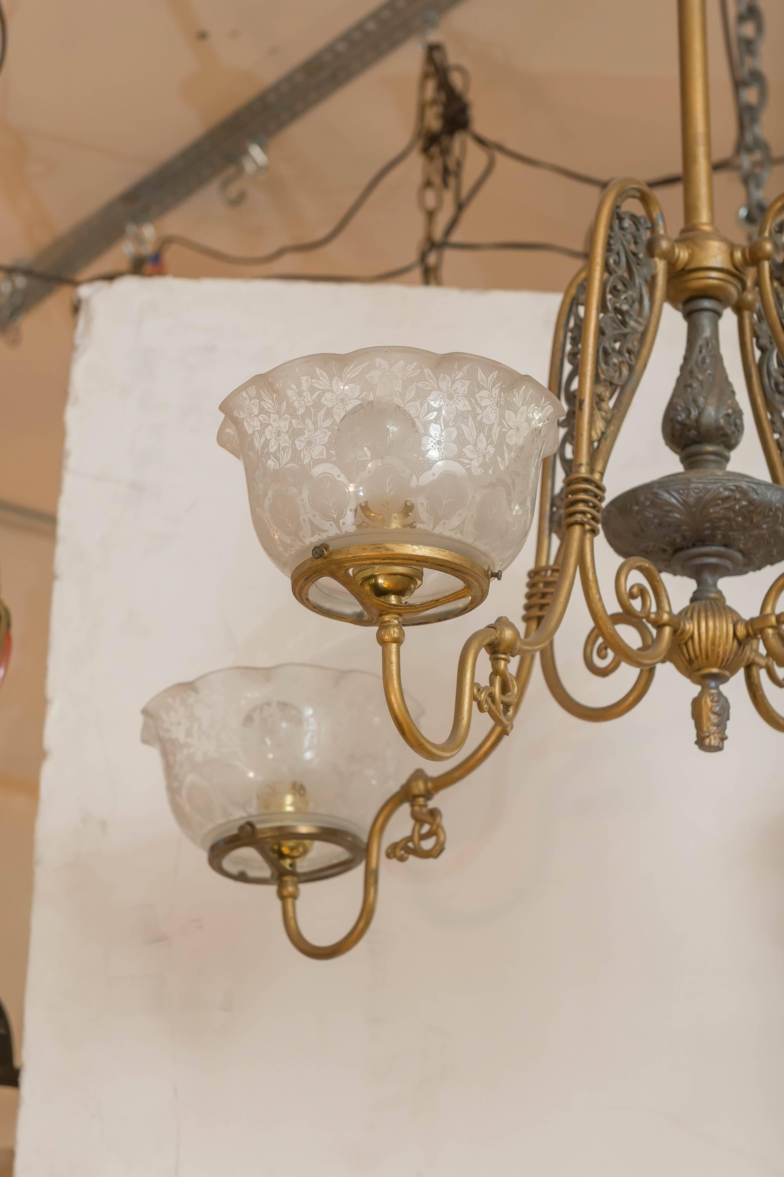 This nice four-arm gas chandelier has been converted to electricity for your convenience. The body has a nice original two-tone finish, and the shades are period to the light. Please note the gas keys. They are really neat being so twisted like a