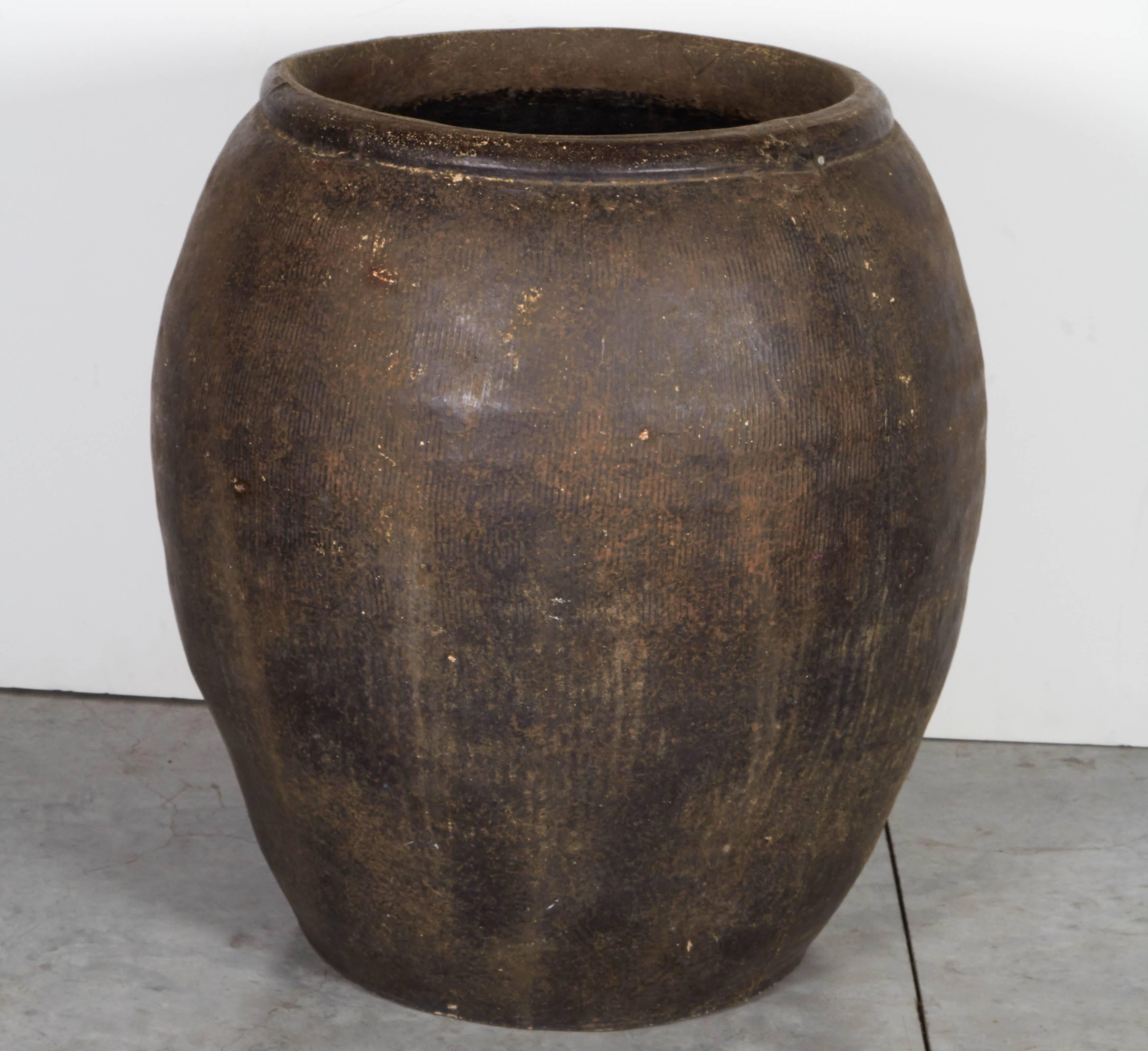 A large, wide and heavy vintage clay jar from Thailand with attractive embossing and a small drainage hole at the bottom. This piece has a strong presence and great functionality.
