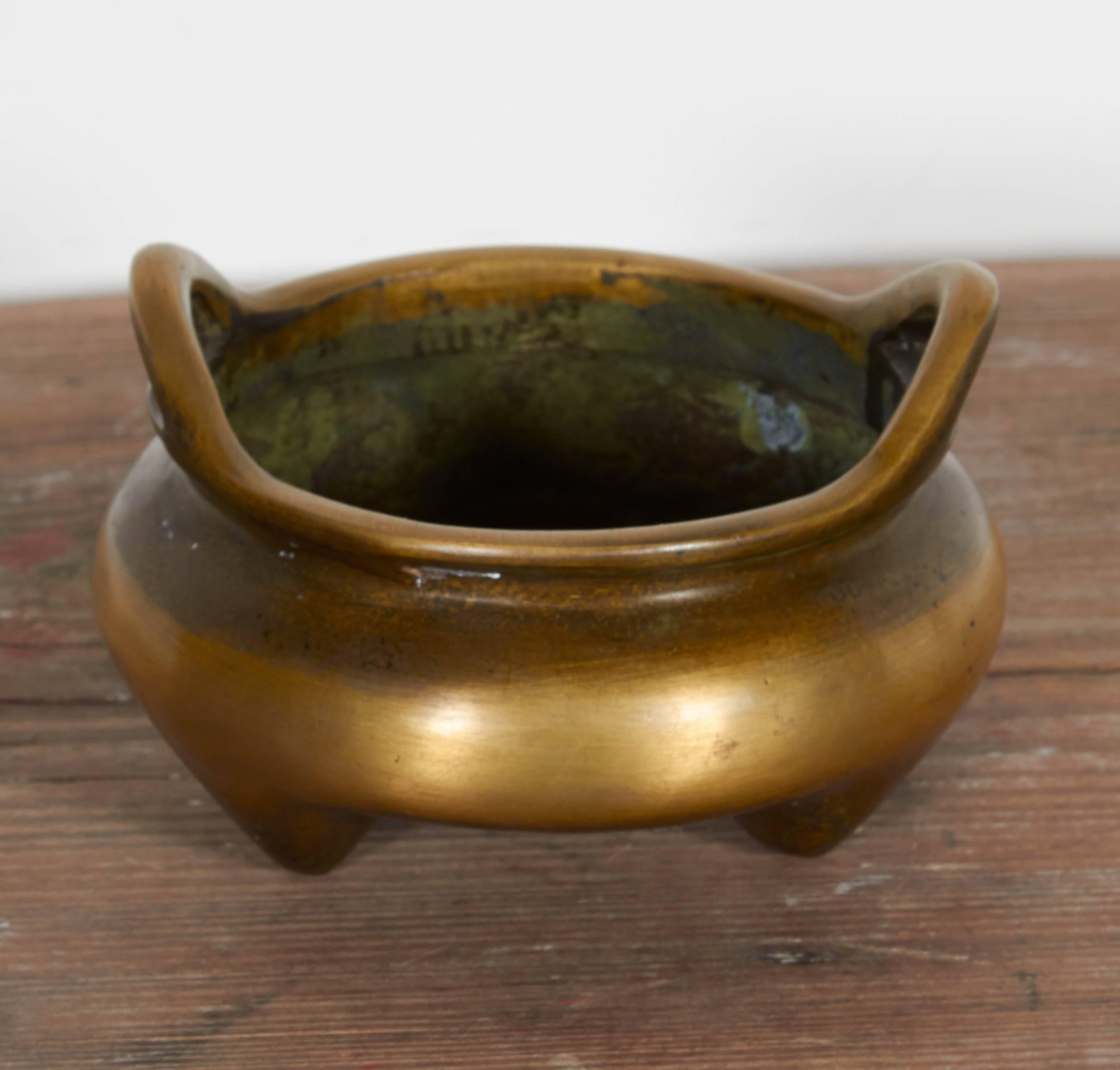 A Classic 19th century (perhaps earlier) bronze Chinese censer with a remarkably simple design and attractive wear and patina. Perfect in a contemporary setting. 
M207.