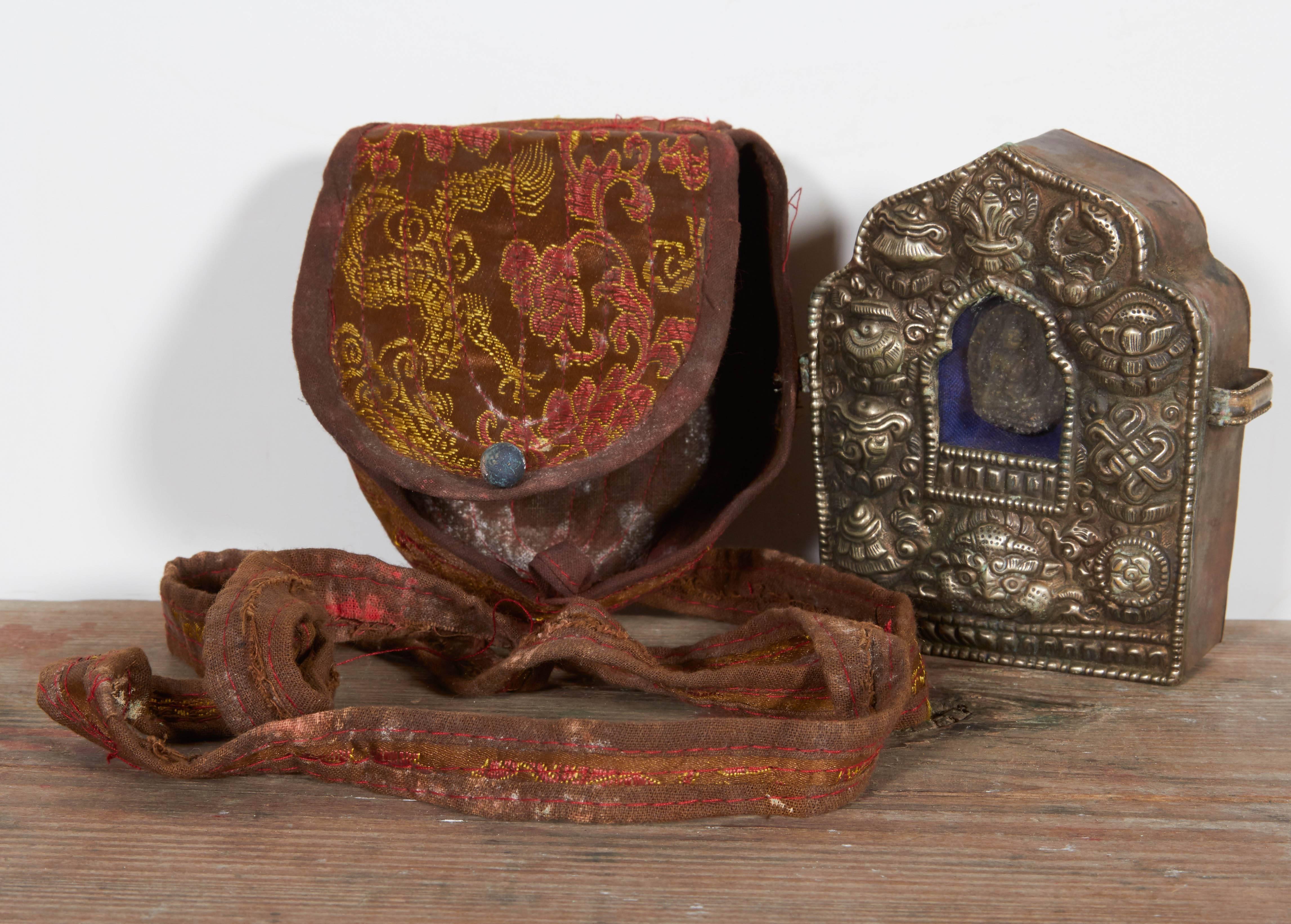 A small Tibetan traveling Buddha shrine (also known as Gau) complete with embroidered fabric carrying case and strap as well as small Buddha inside. These shrines were often carried by monks or other followers of Buddha when they left their homes.