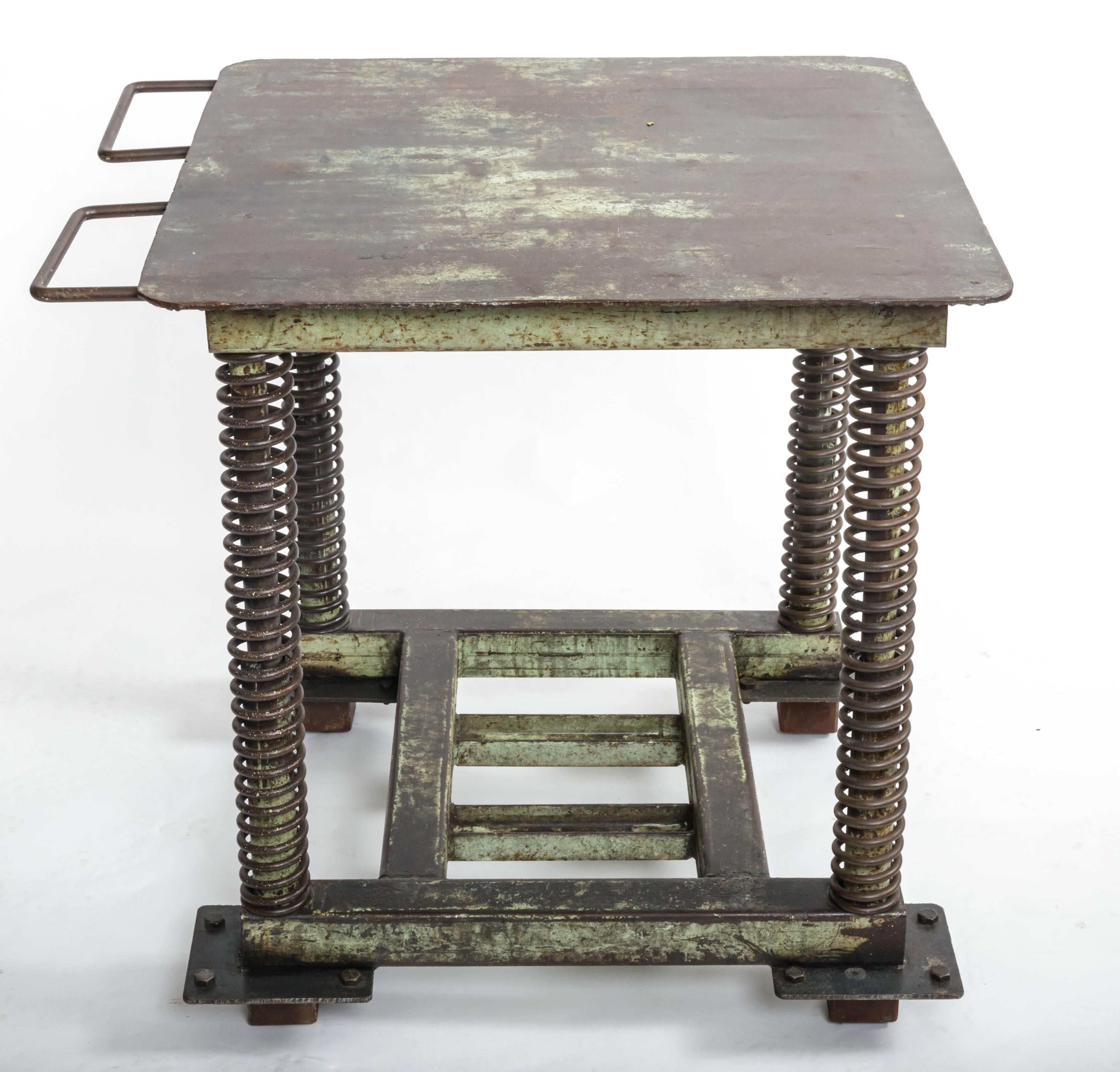 Green patinated steel industrial table, United States, 20th century.

This storied piece includes a handsome industrial frame, good-looking spring legs, generous surface space and a charming patina. 
 