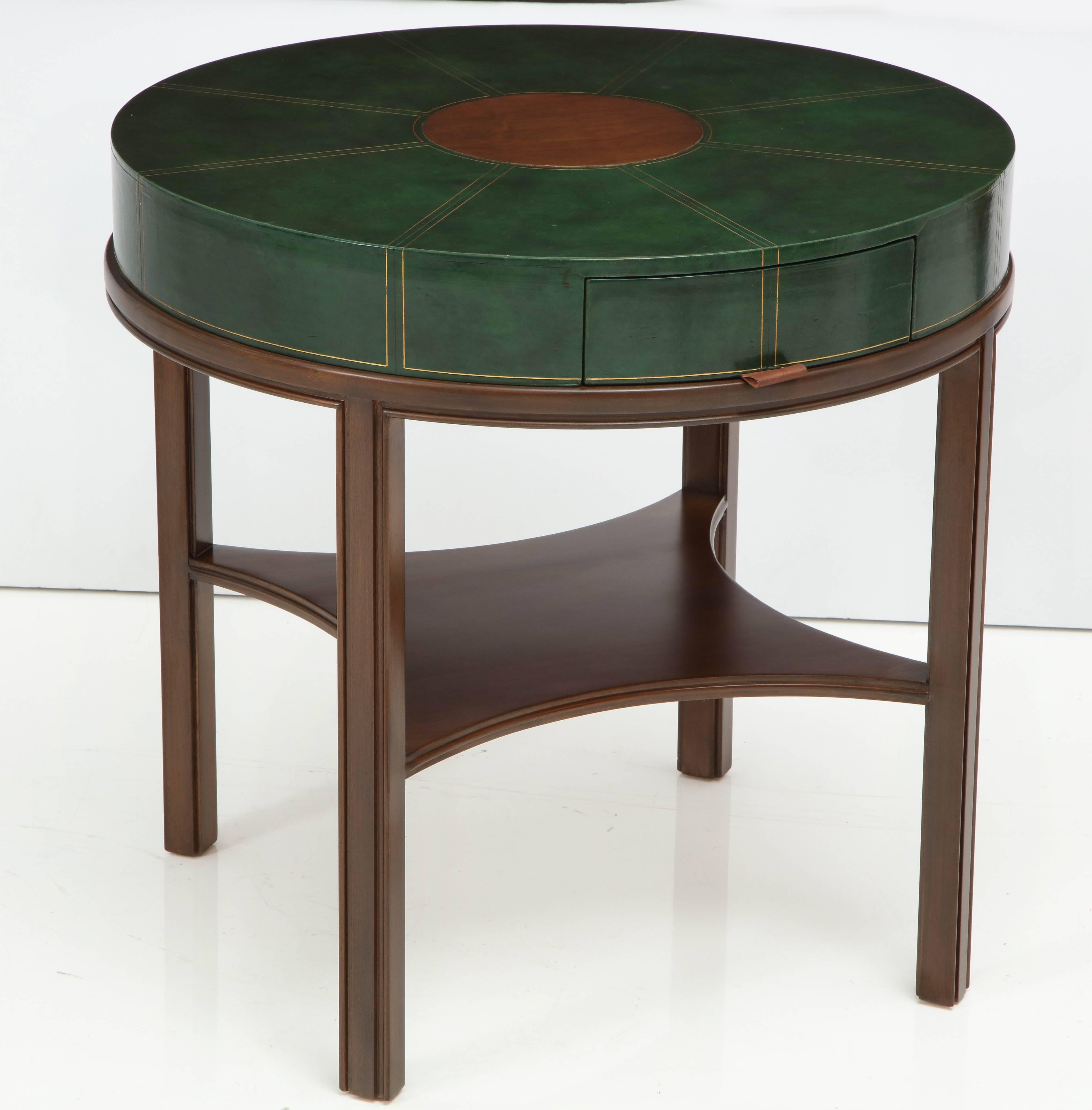 Midcentury walnut lamp table featuring a forest green leather top with hand tooled pinstripe accents with a walnut disc centre and a hidden drawer with a simple leather tab. Mint restored, with slight wear to leather. Label inside drawer.