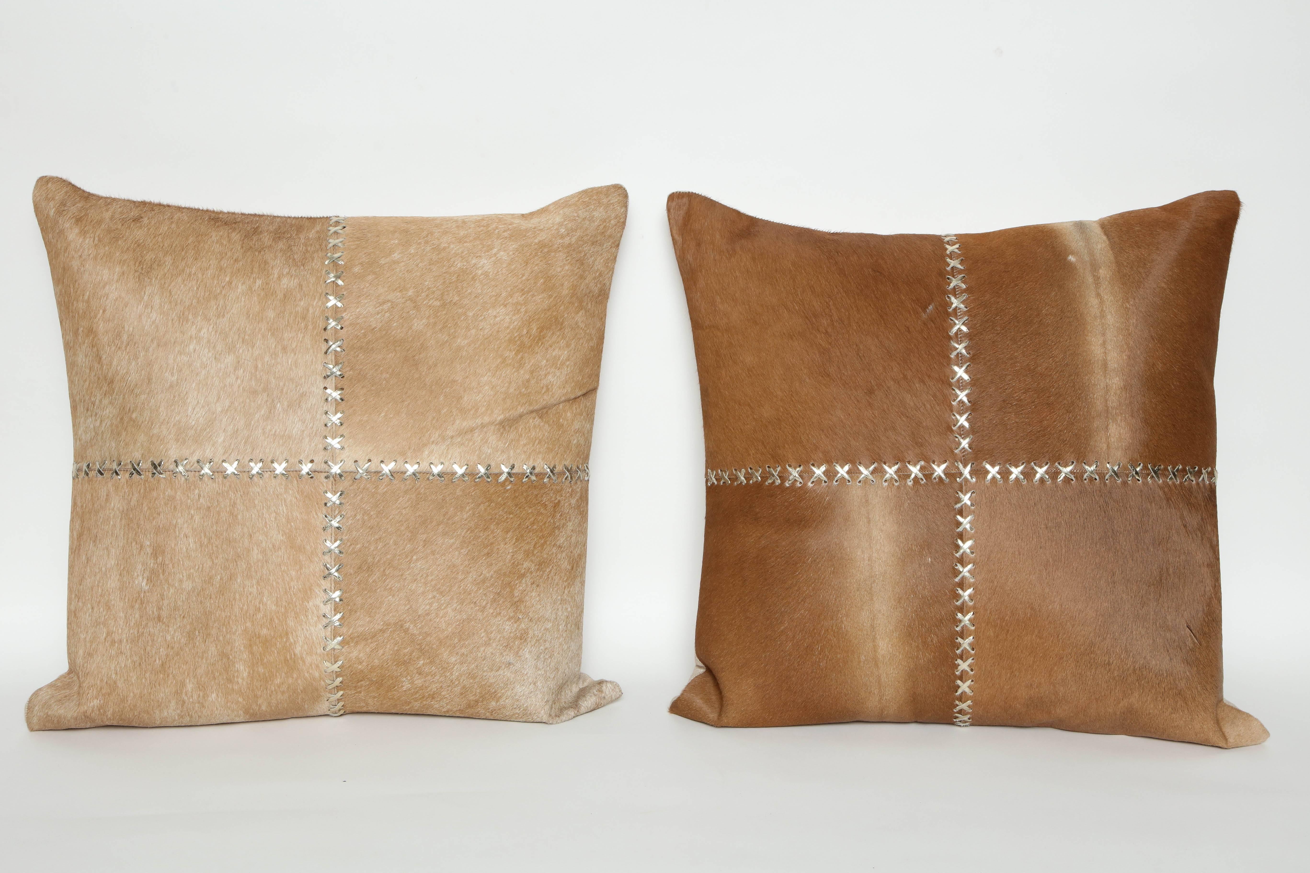Pair of custom-made caramel colored hide pillows with gold metallic X-lace up and cotton/linen backs, zipper closure. Feather/down inserts.