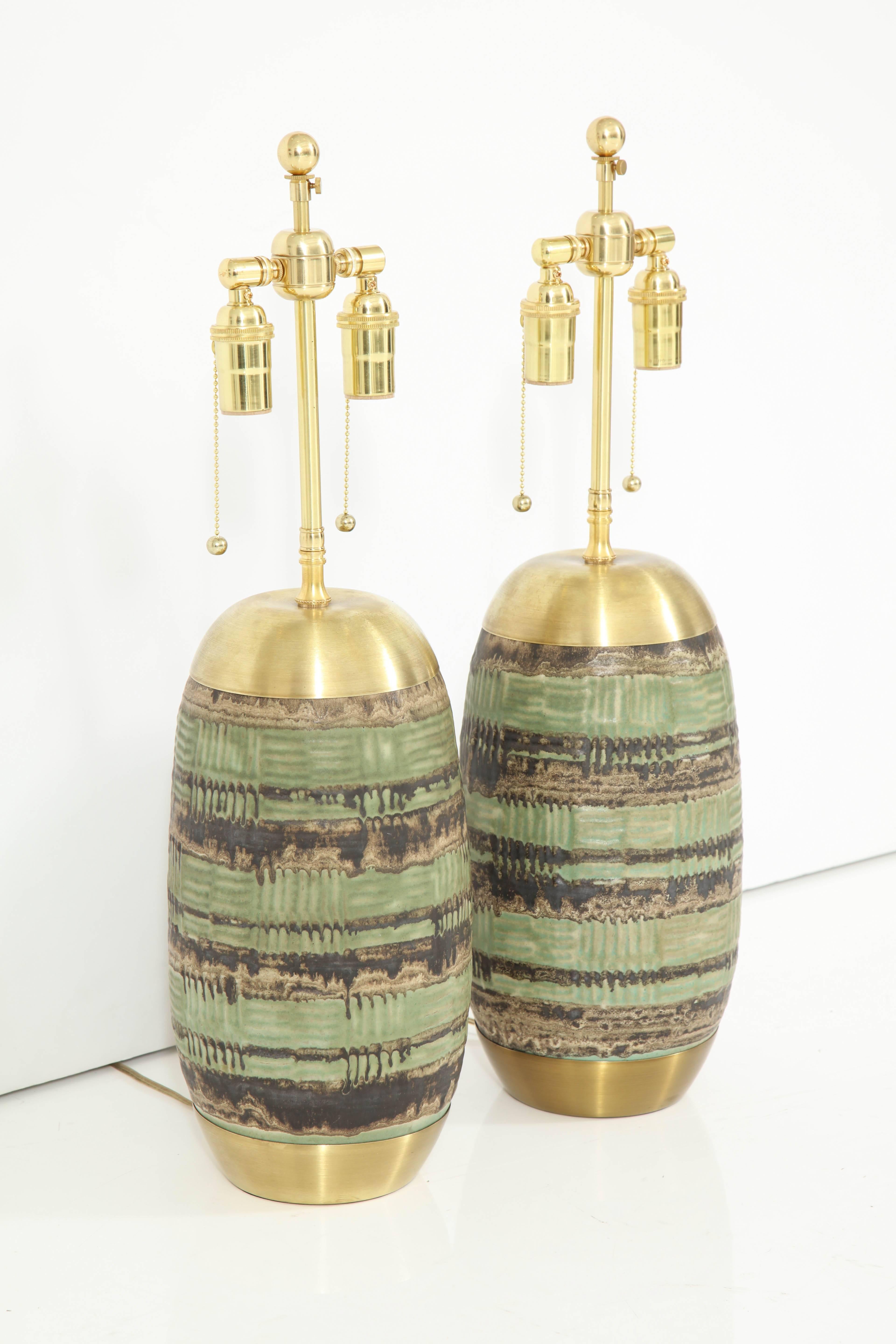 Pair of 1960s Italian ceramic lamps.
The lamp bodies have a nice green and earth tone glaze finish and are set in brass bases and they have been newly rewired for the US with polish brass double clusters that take standard light bulbs.