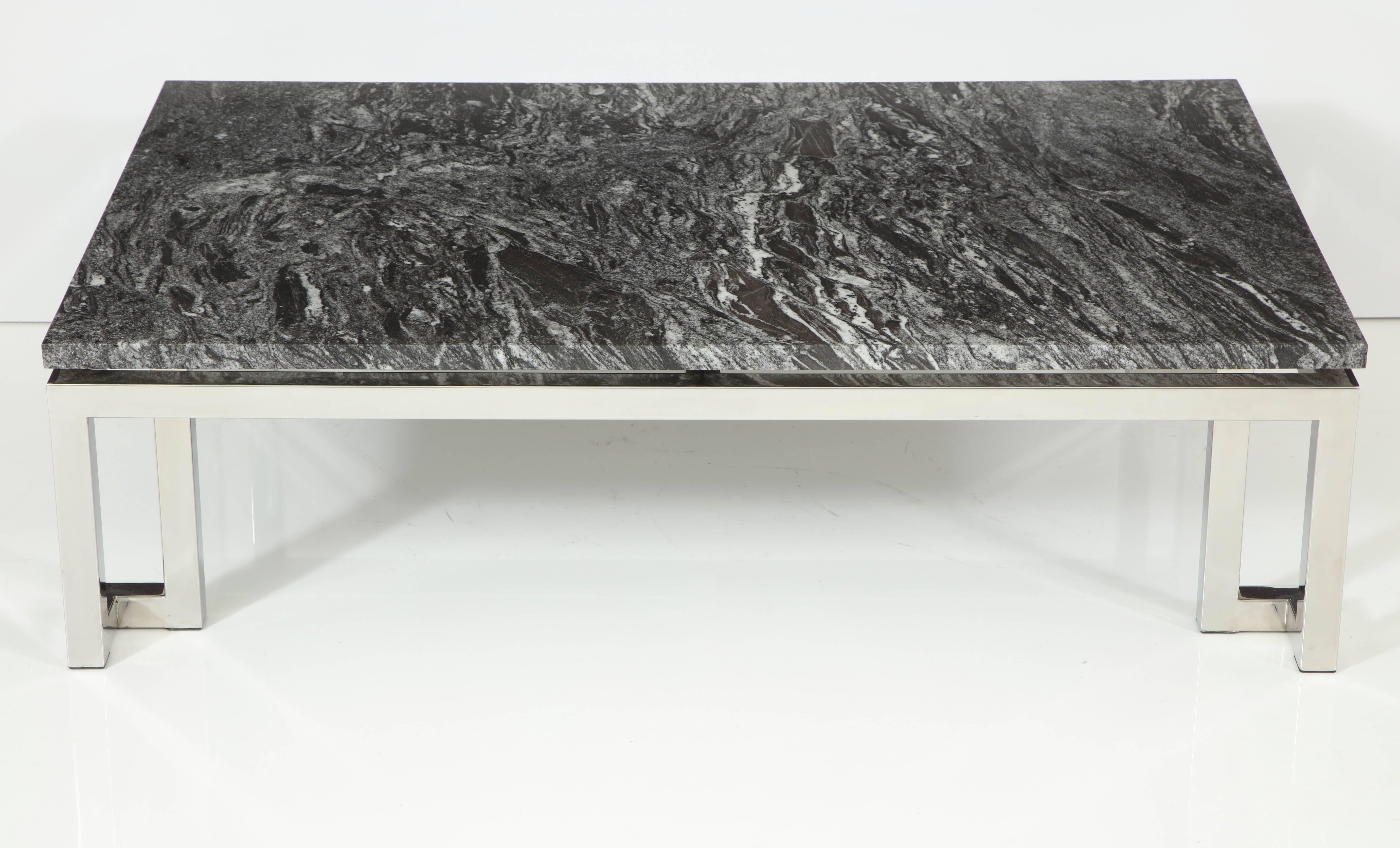 Élégante table basse en chrome poli d'influence grecque. 
Le magnifique plateau en granit flotte au dessus de la base.