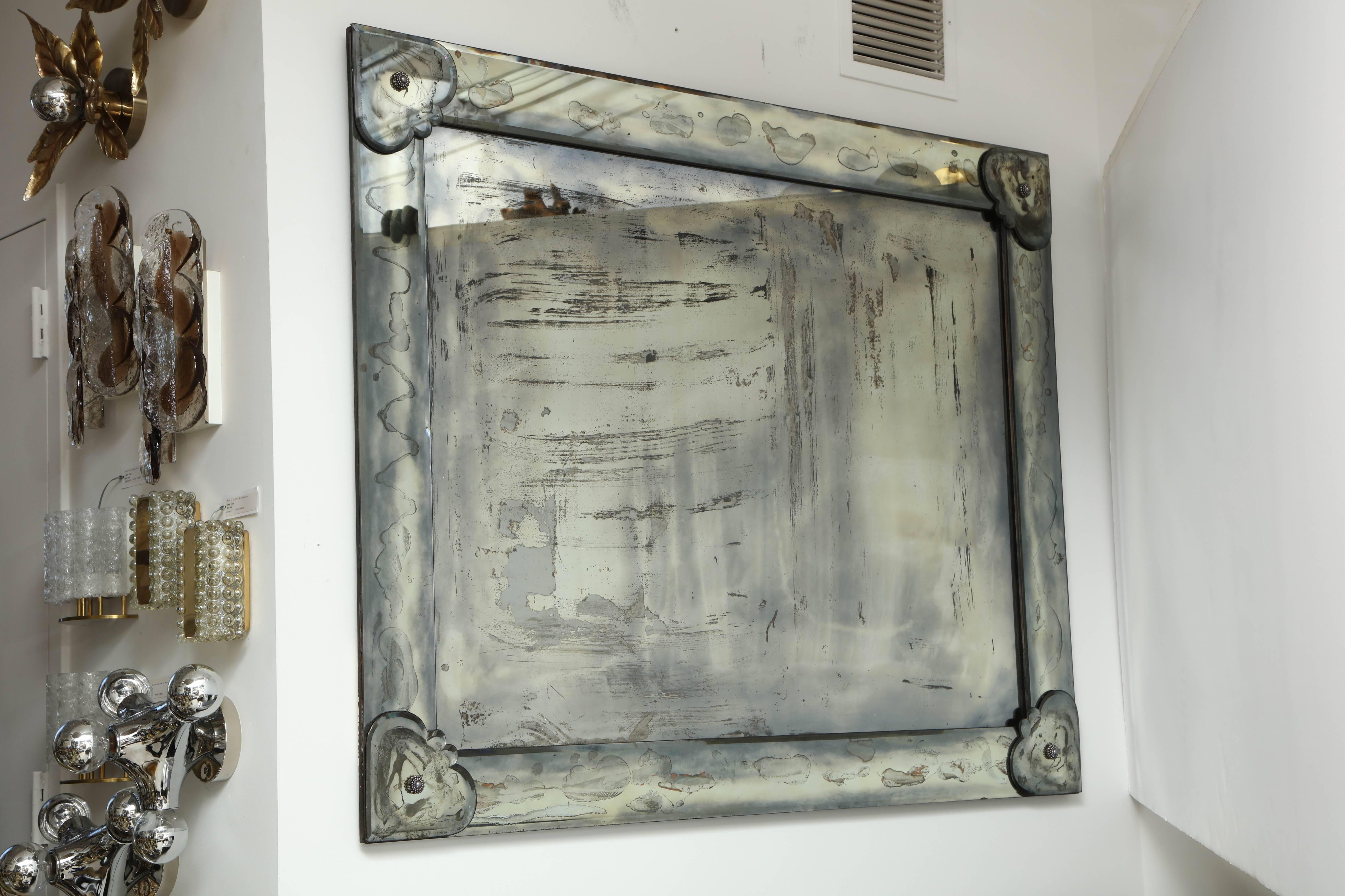 Exquisite 1950s large Venetian style mirror by James Mont.
Antiqued mirror with a cloudy and just the right amount of patination for that Glamorous smokey reflection.
The mirror has been stabilized with an enclosed back and has hardware attached