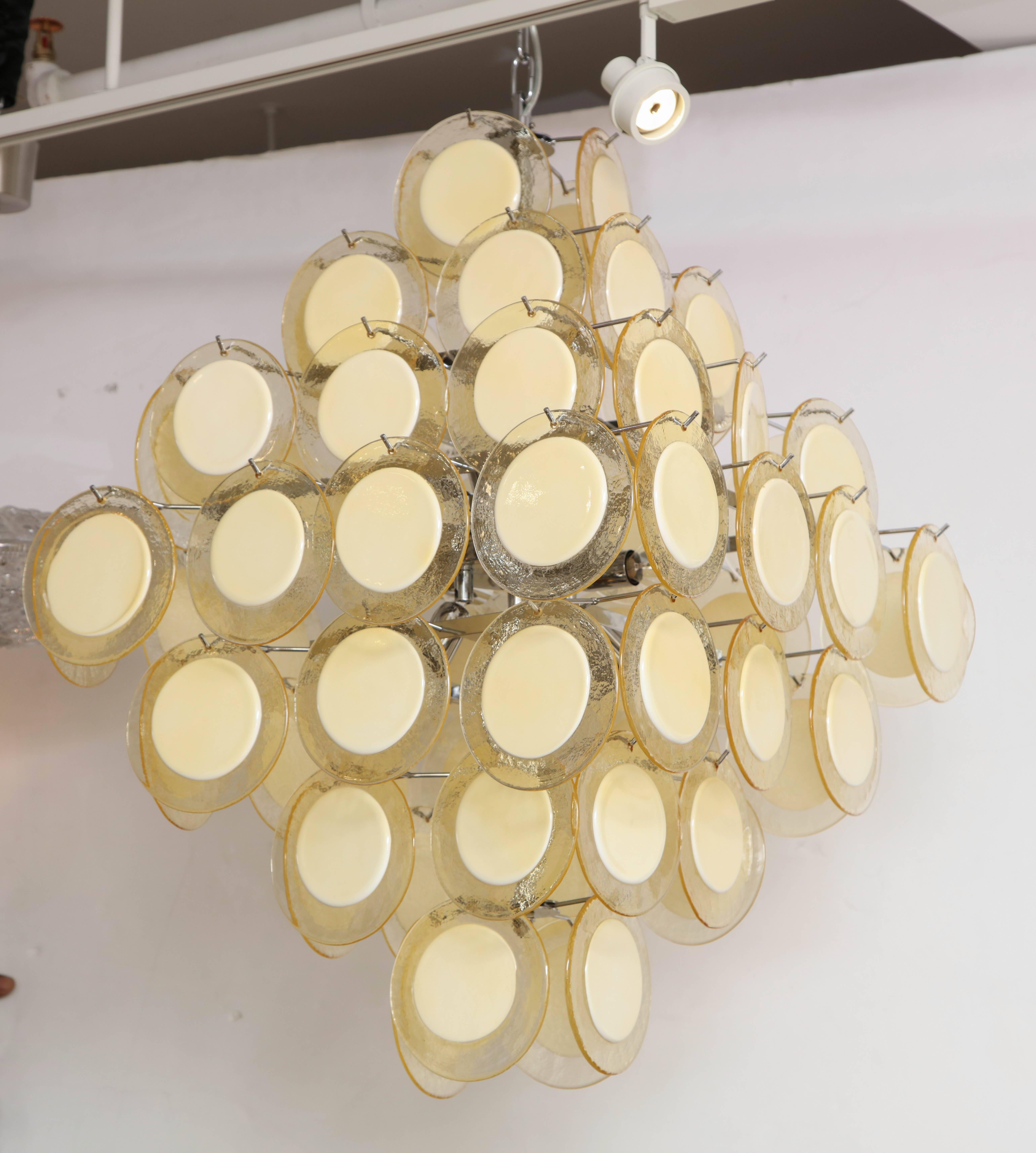 Vistosi influenced, golden champagne colored Murano glass disc chandelier with contrasting opaque centers. Glass discs are suspended on a nickel frame and has been wired for use in the USA. Polished nickel canopy and 18