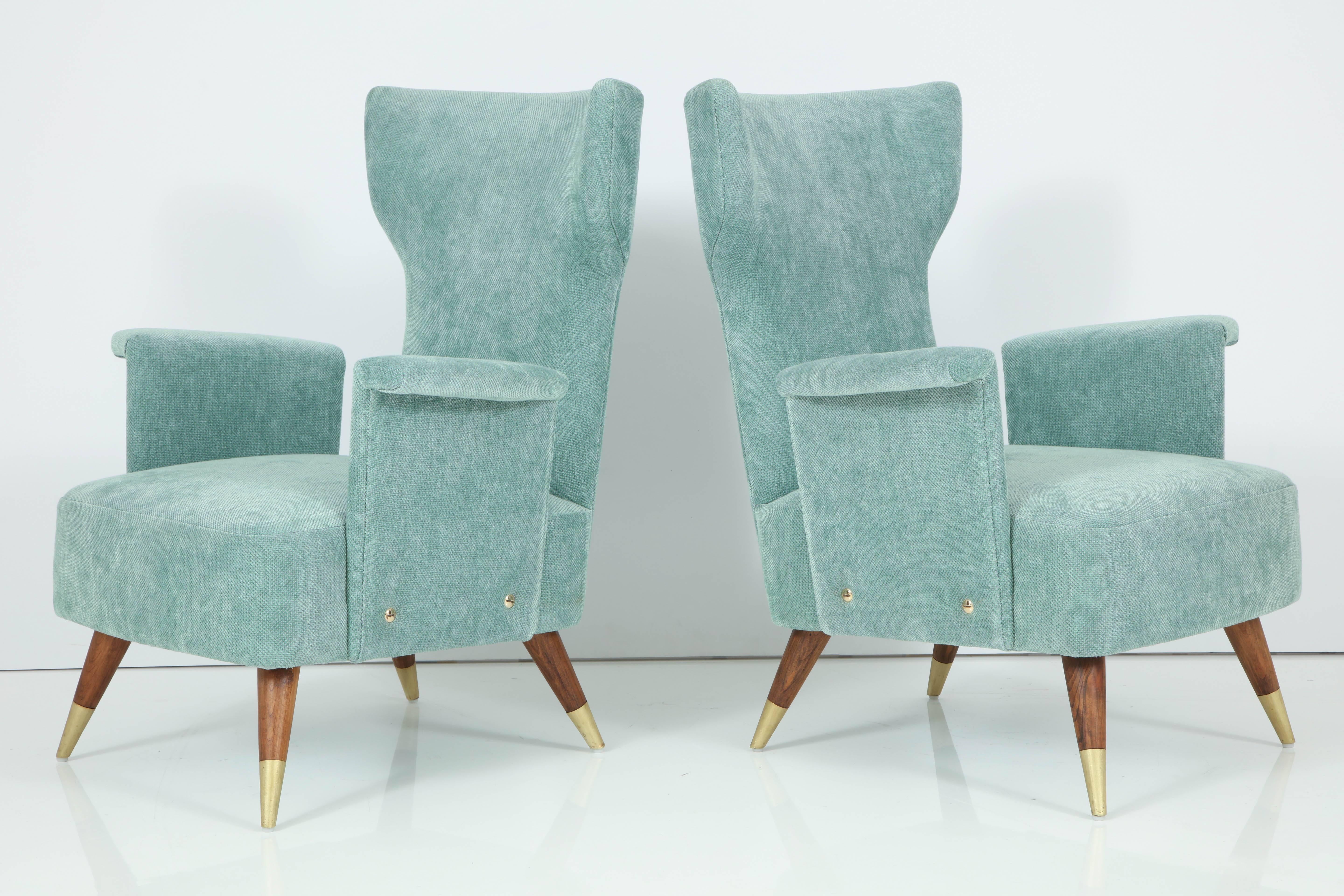 Very elegant pair of wingchairs with detached arms on wood and brass legs.
Another pair is available for COM upholstery.