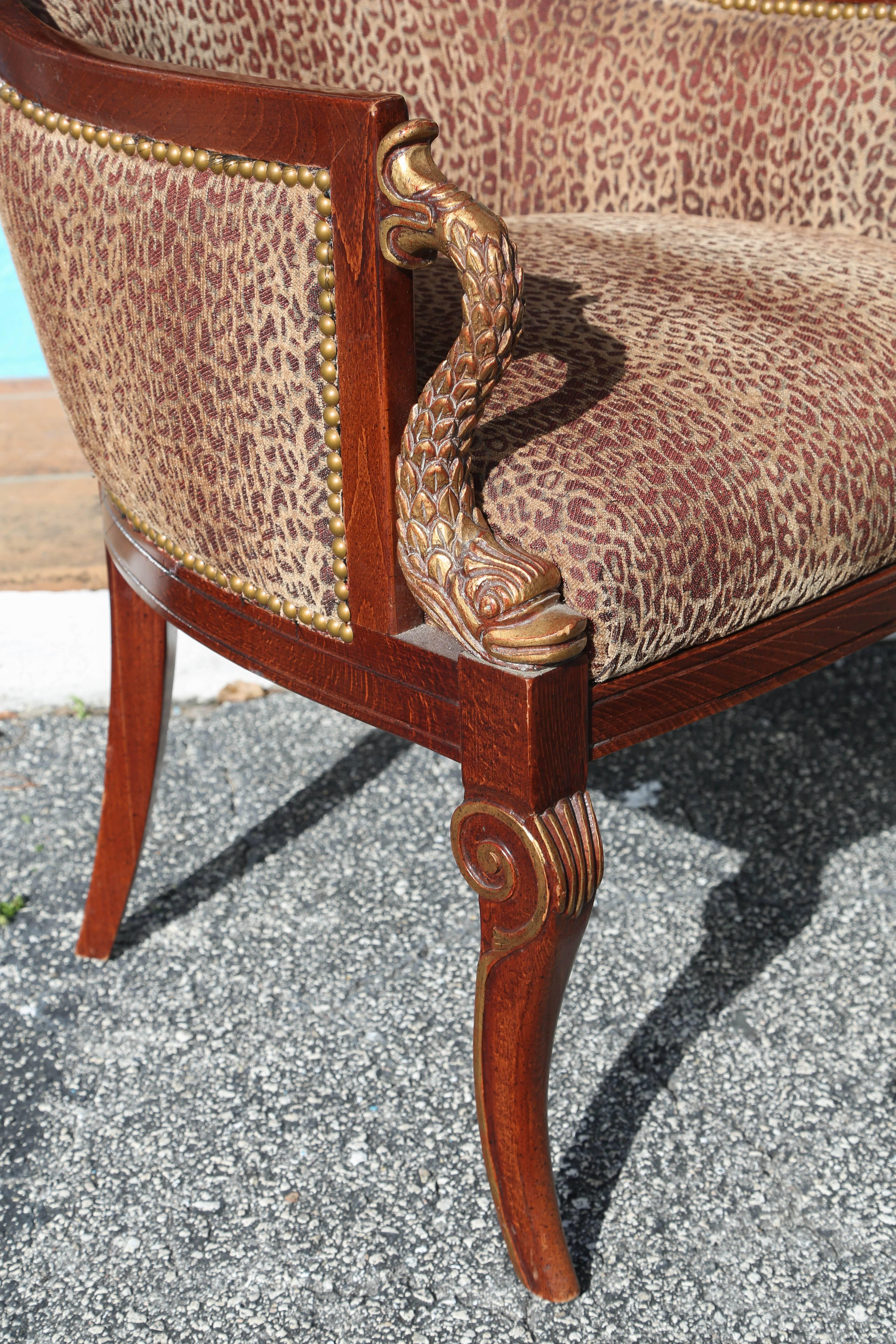 A wonderful pair appointed with giltwood dolphin motif arm rests and covered with stunning baby leopard print fabric outlined with nailheads.