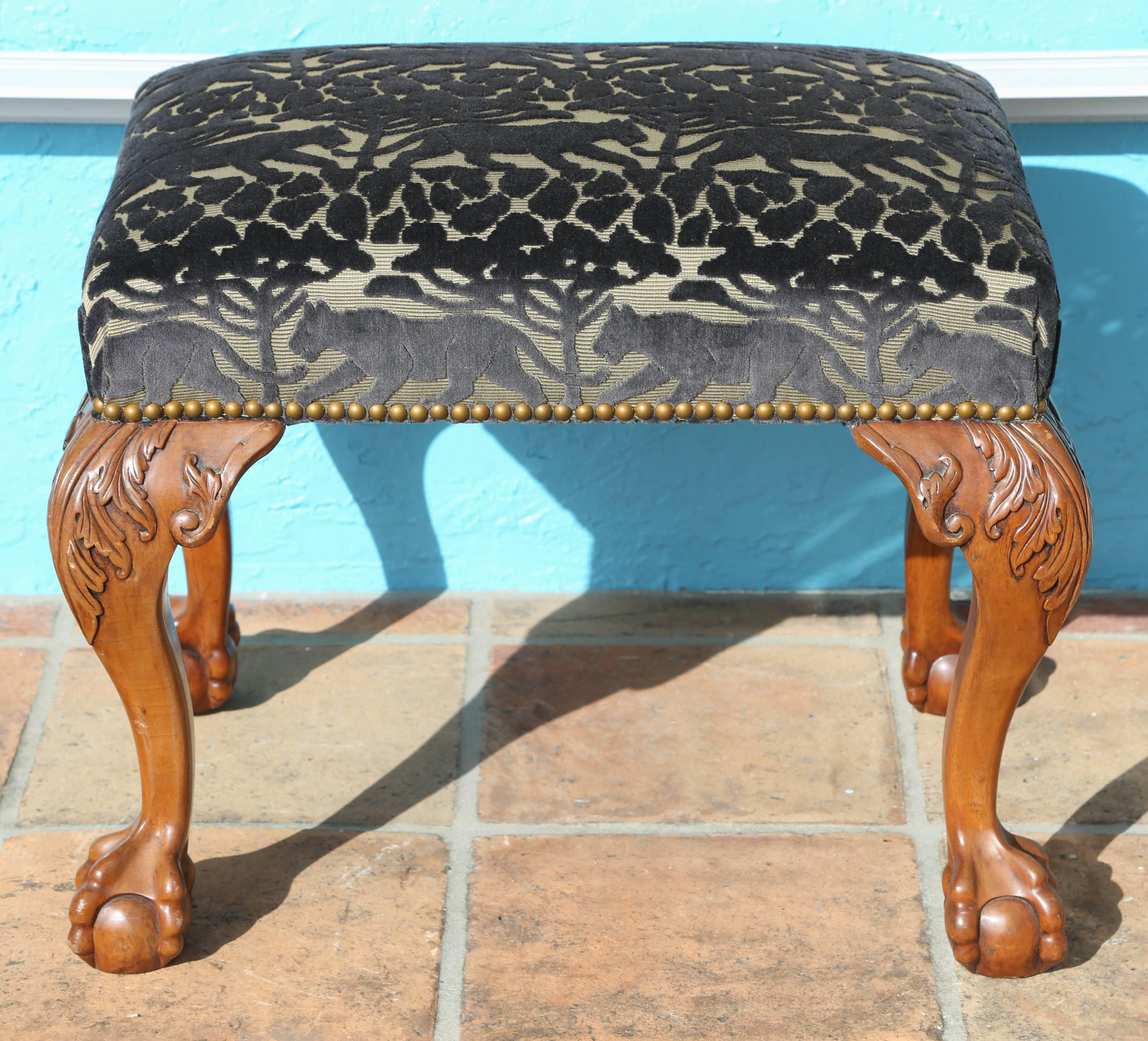 Covered with a cut velvet panther motif fabric the dramatic pair features crisp carving terminating in claw feet.
