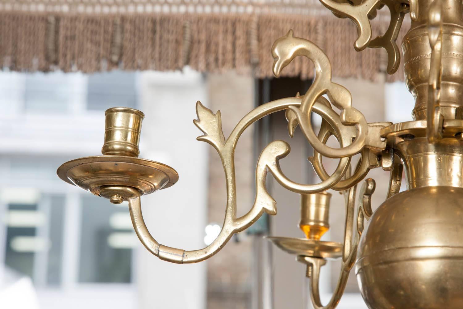 An alluring Anglo-Dutch period brass chandelier dating from the second half of the 17th century. The chandelier has a tier of reflector rosettes to disperse the candle light better. There are old restoration braces to some of the arms.