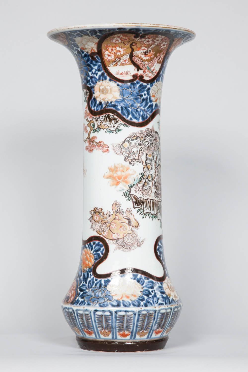 An exquisite pair of early 18th century Japanese Imari trumpet vases. Each central panel decorated with a beautifully depicted kara shi-shi lions and framed by borders of blue scrolling flowers on a dark blue and gold background. 
Condition: very