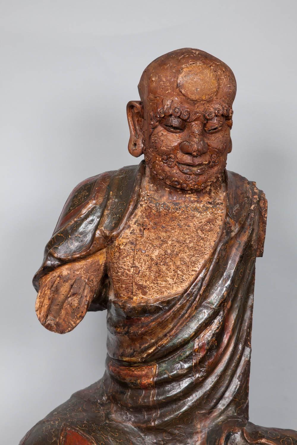 An impressive Chinese wooden figure of a Luohan dating circa 1550.
The carving of the face is particularly fine and expressive, the paintwork on the body is the original one and in very good original state.
The arms are missing.

The sculpture