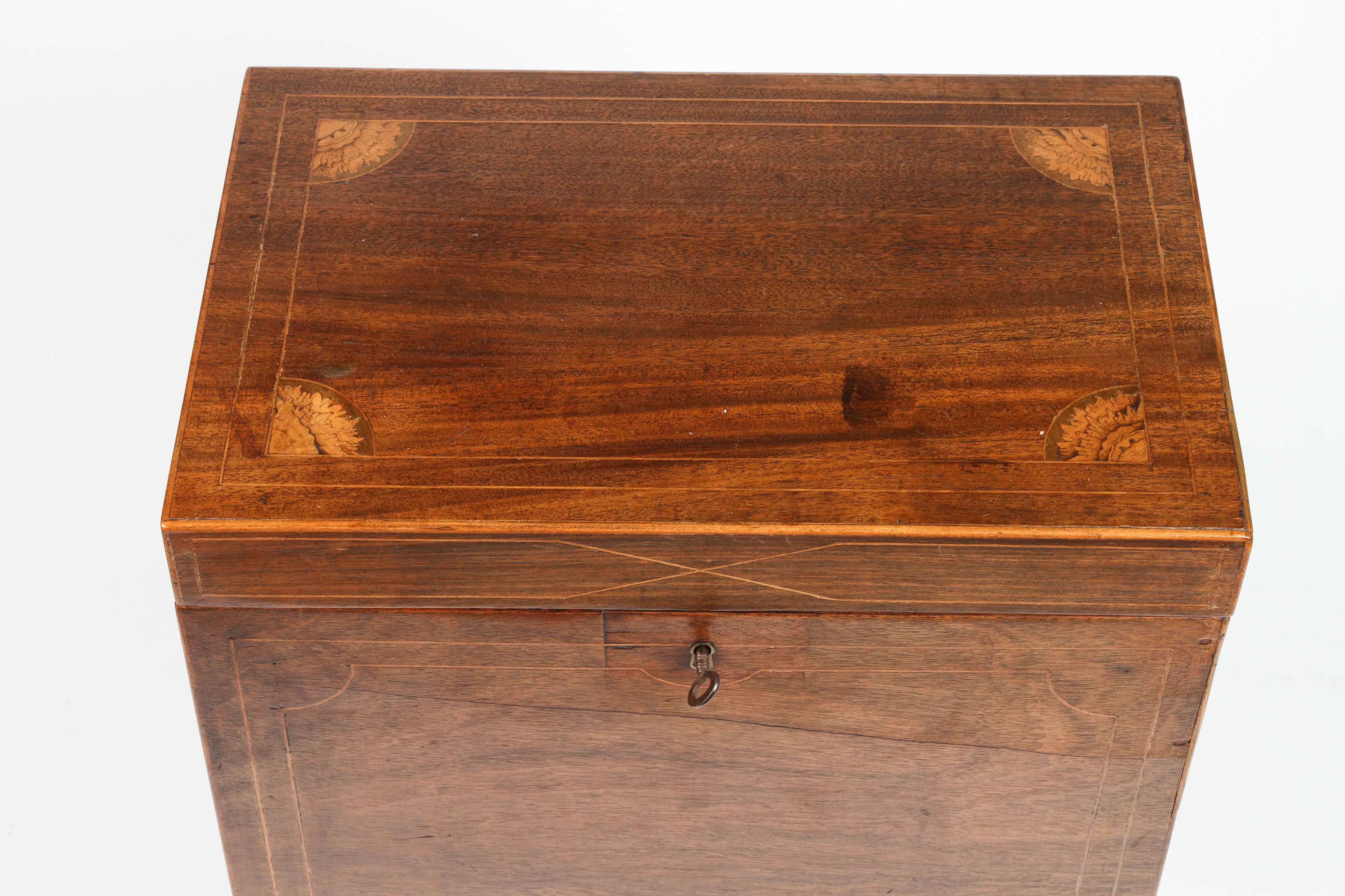 A Sheraton Mahogany Cellarette on a Stand from 1810. This cellarette has an elegant inlay top with leaf design, as well as an interior made to store wine and alcohol in the dining room. 