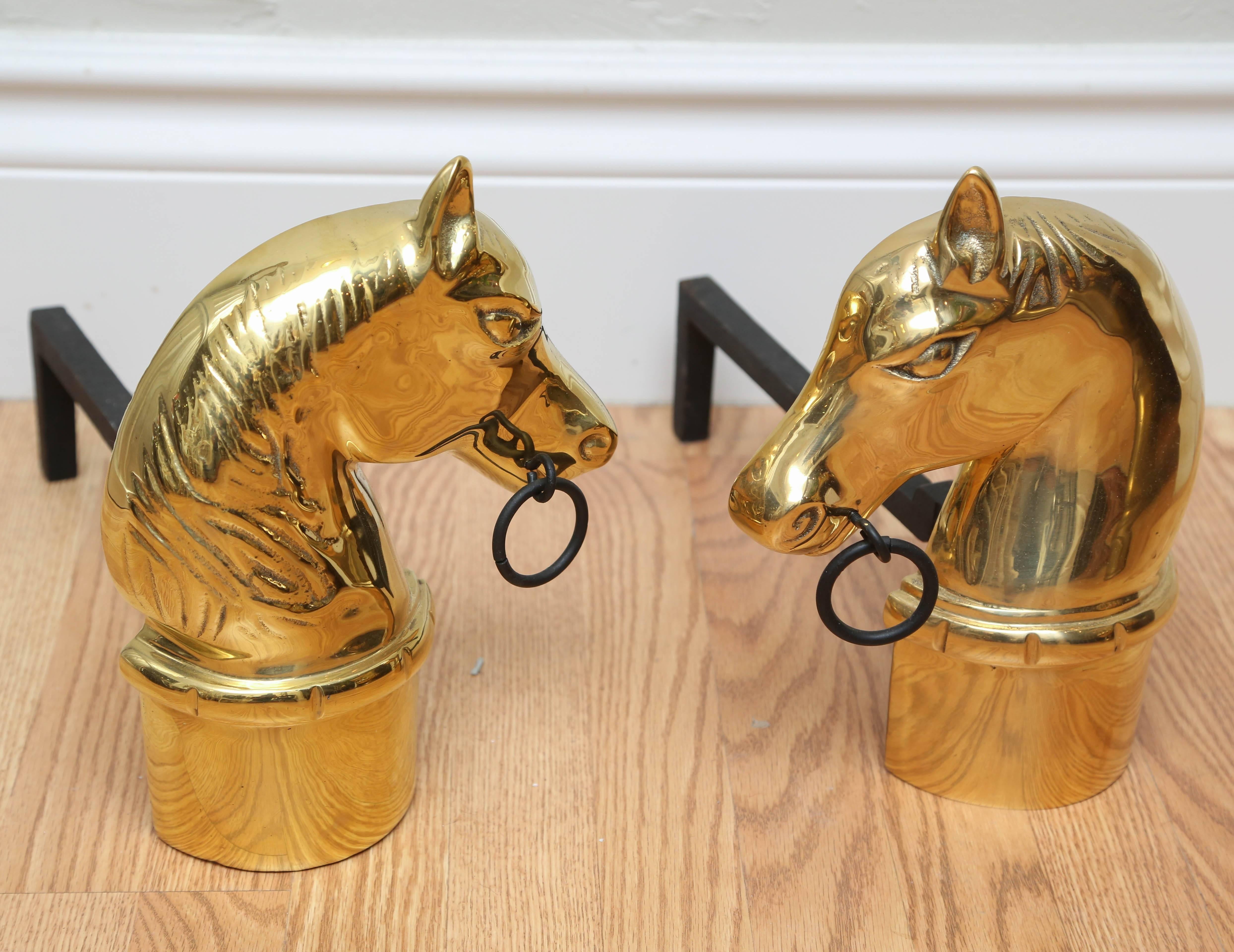 Pair of brass horse head andirons with black iron ring and base.