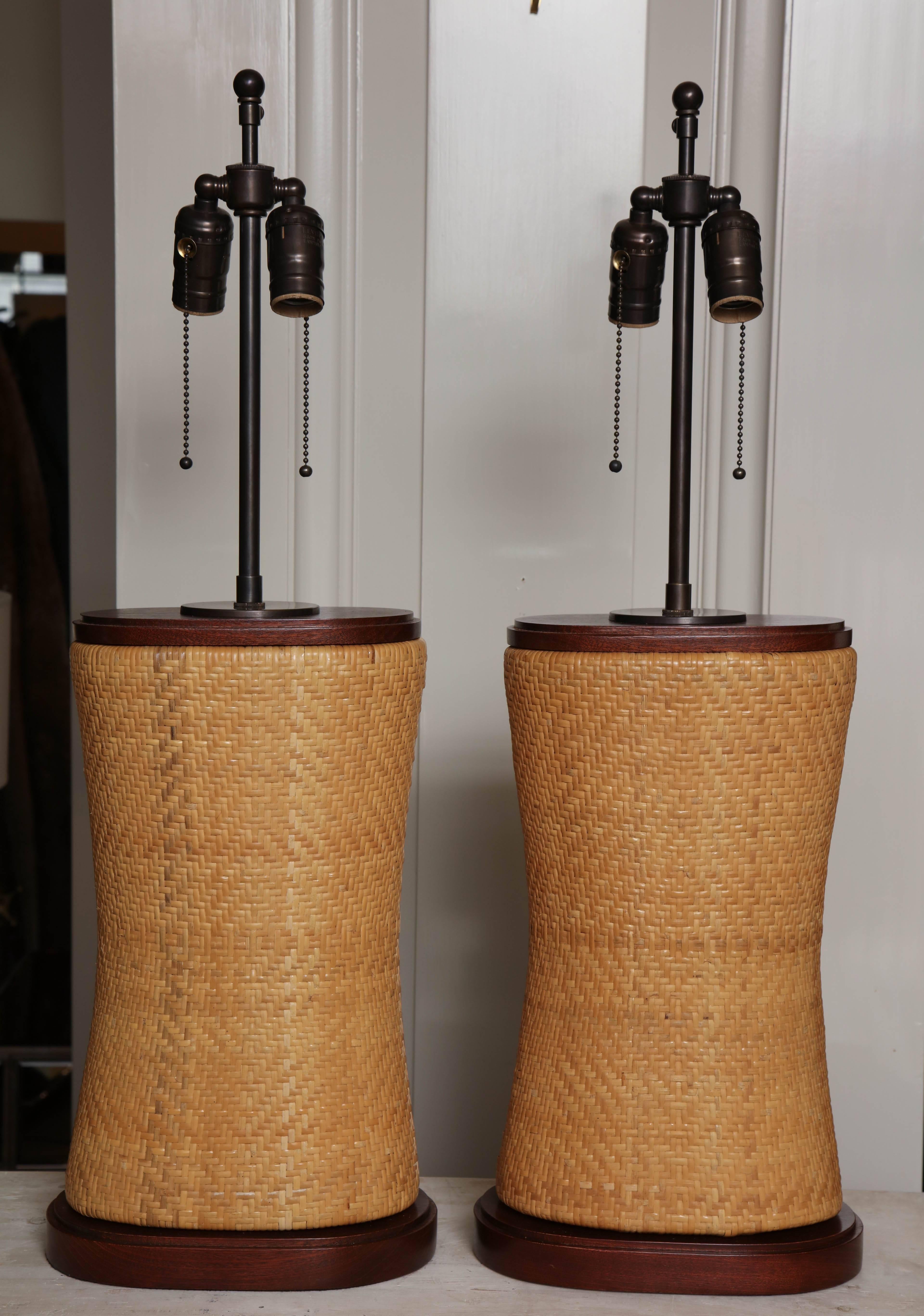 Pair of Japanese neck pillows, circa 1950 mounted as lamps with custom mahogany stepped bases and bronze finished brass hardware, ivory woven oval shades with rolled edges included but not shown here.