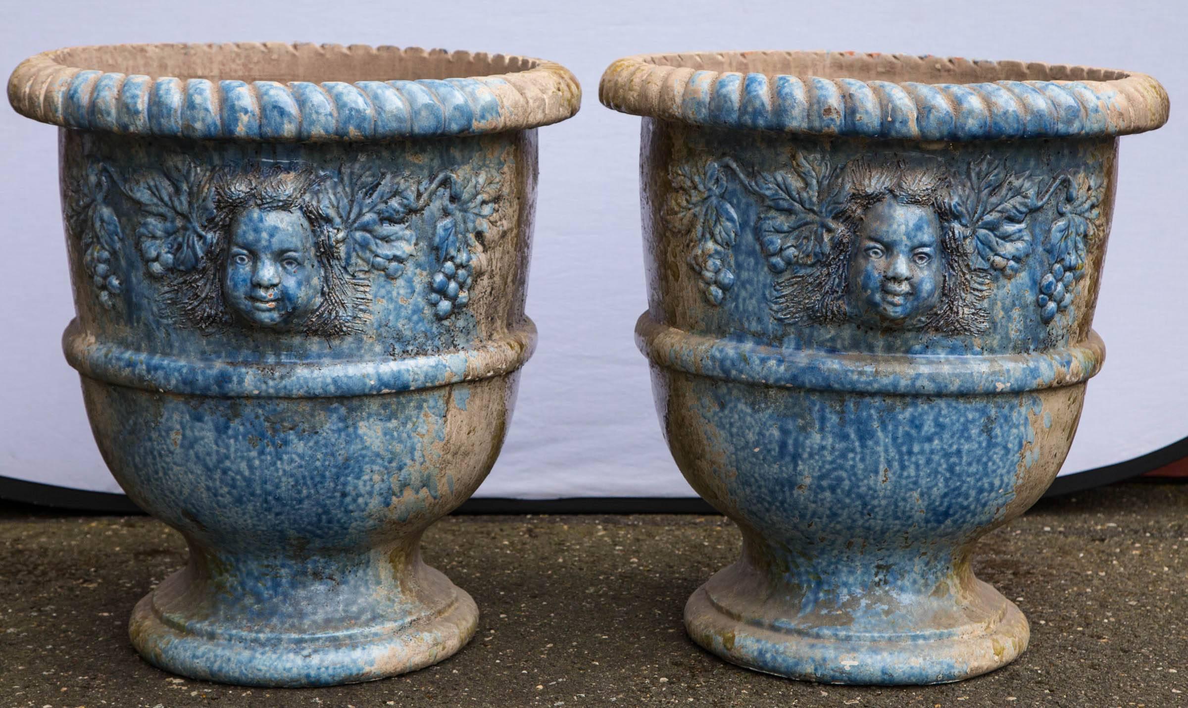 Pair of blue and green dappled glazed terracotta cherub face relief planters.