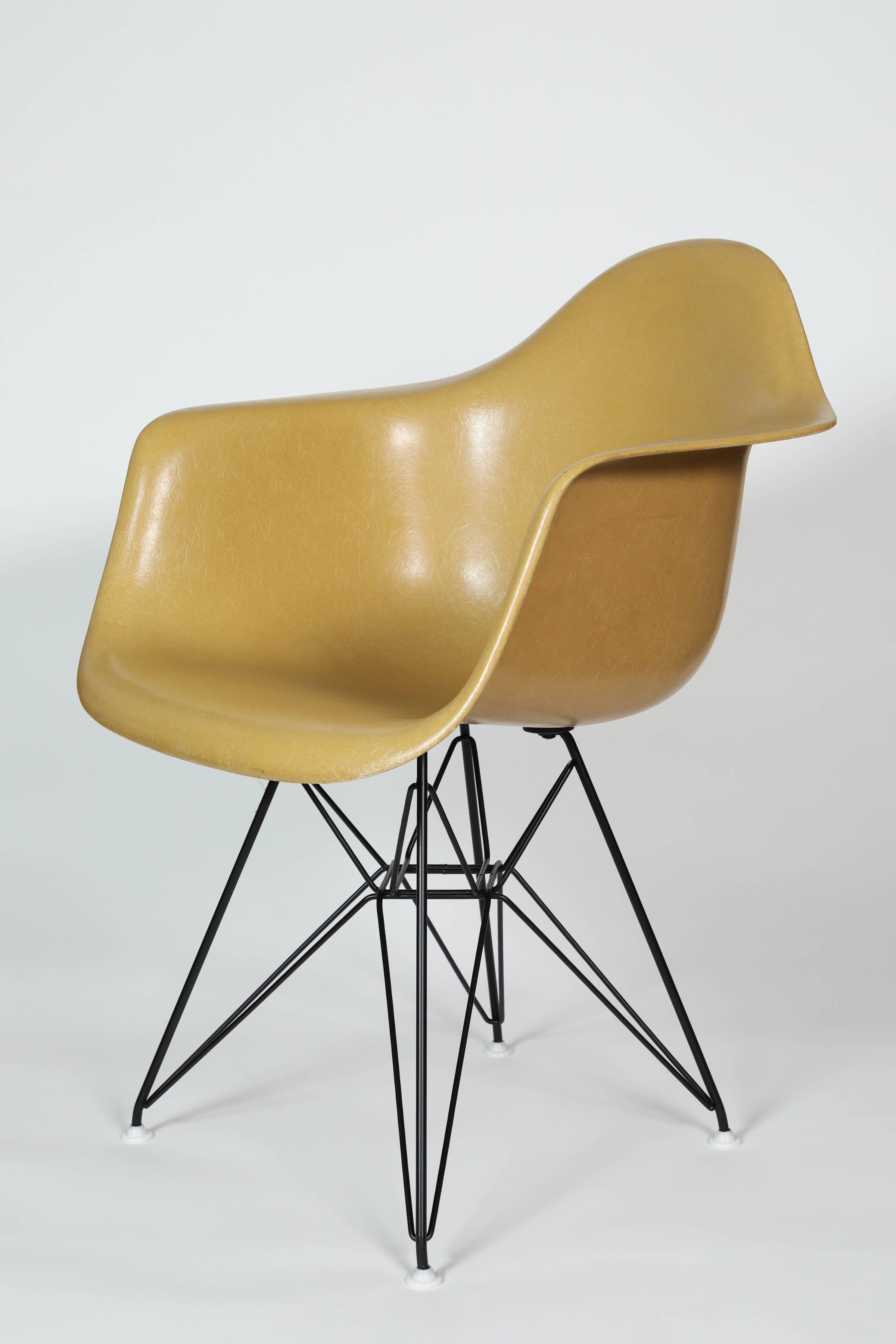 Set of four mustard colored Eames Herman Miller fiberglass shell armchairs, with original Herman Miller mark. Eiffel tower base is in great condition.
 
