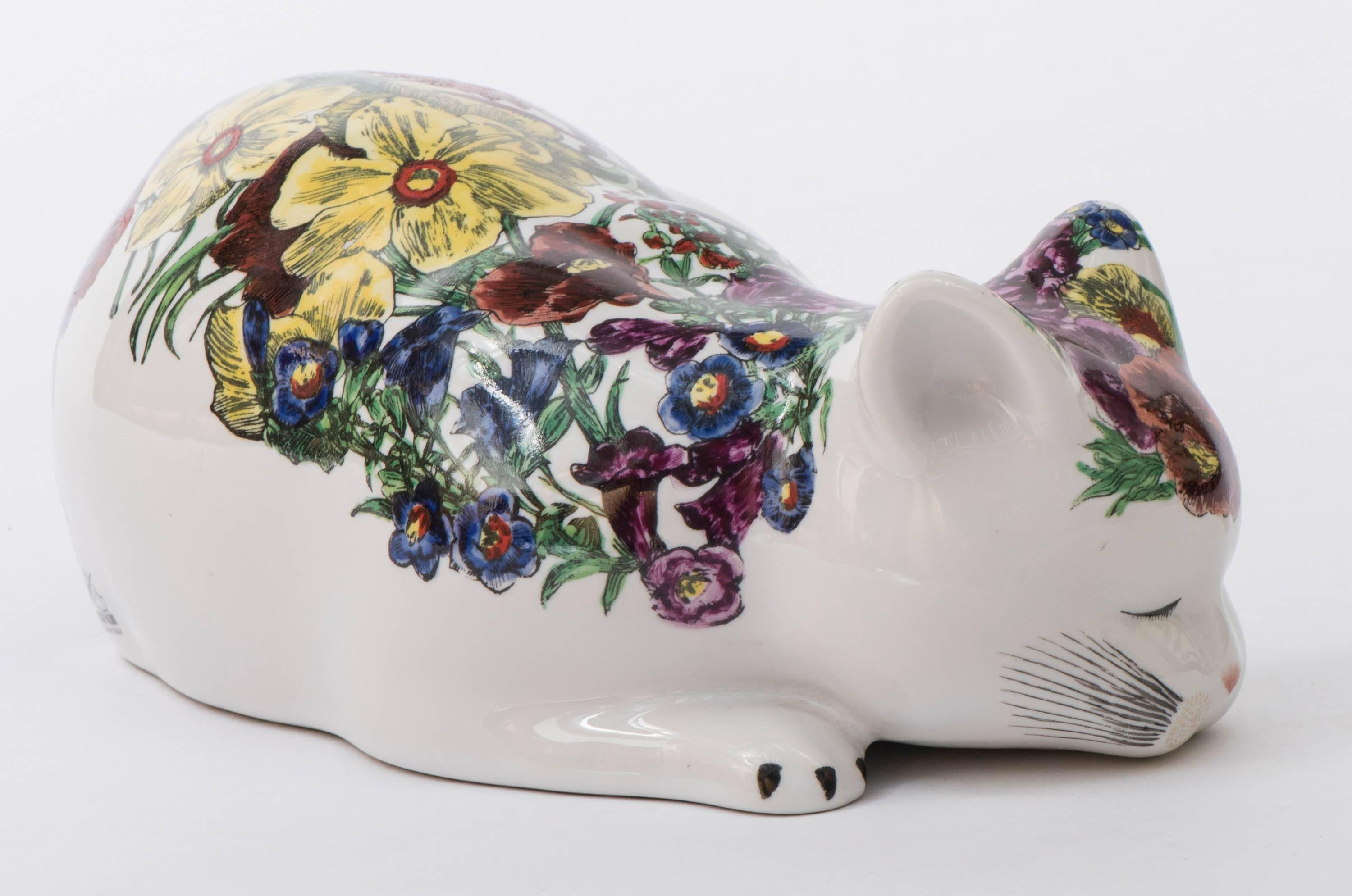 Sleeping porcelain cat by Piero Fornasetti.
“Gatto avvocacciato florata”
Lithographically printed and hand-colored. 
Painted with flora and foliage.
Italy, circa 1960.
Marked to base.
Measures: 12.5 cm high x 31 cm wide x 18 cm deep.
  