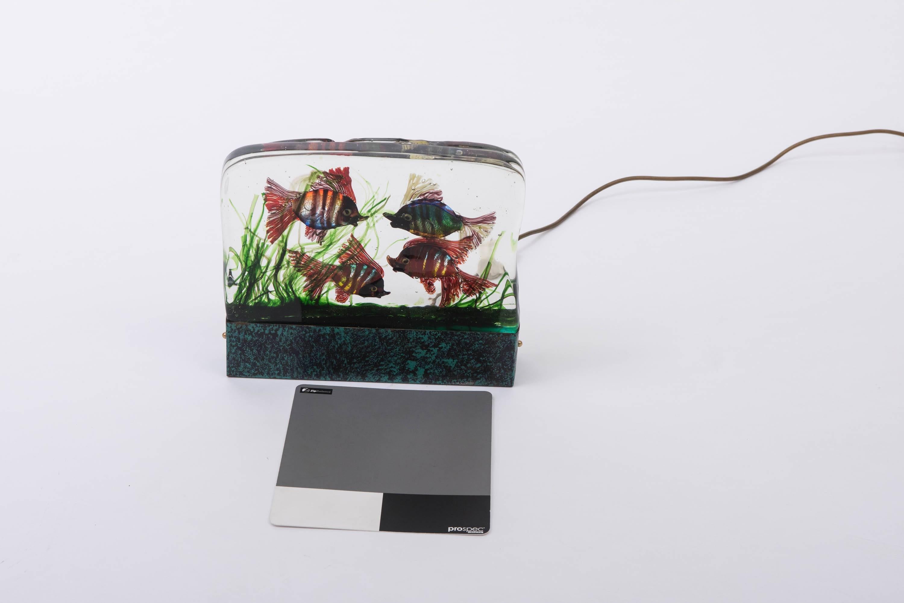 A Murano glass aquarium lamp by Gino Cendese,
Thick glass panel set with coloured glass fish and seaweed.
Copper metal base.
Italy, circa 1960
Measures: 27 cm high x 31.5 cm wide x 6 cm deep.
 