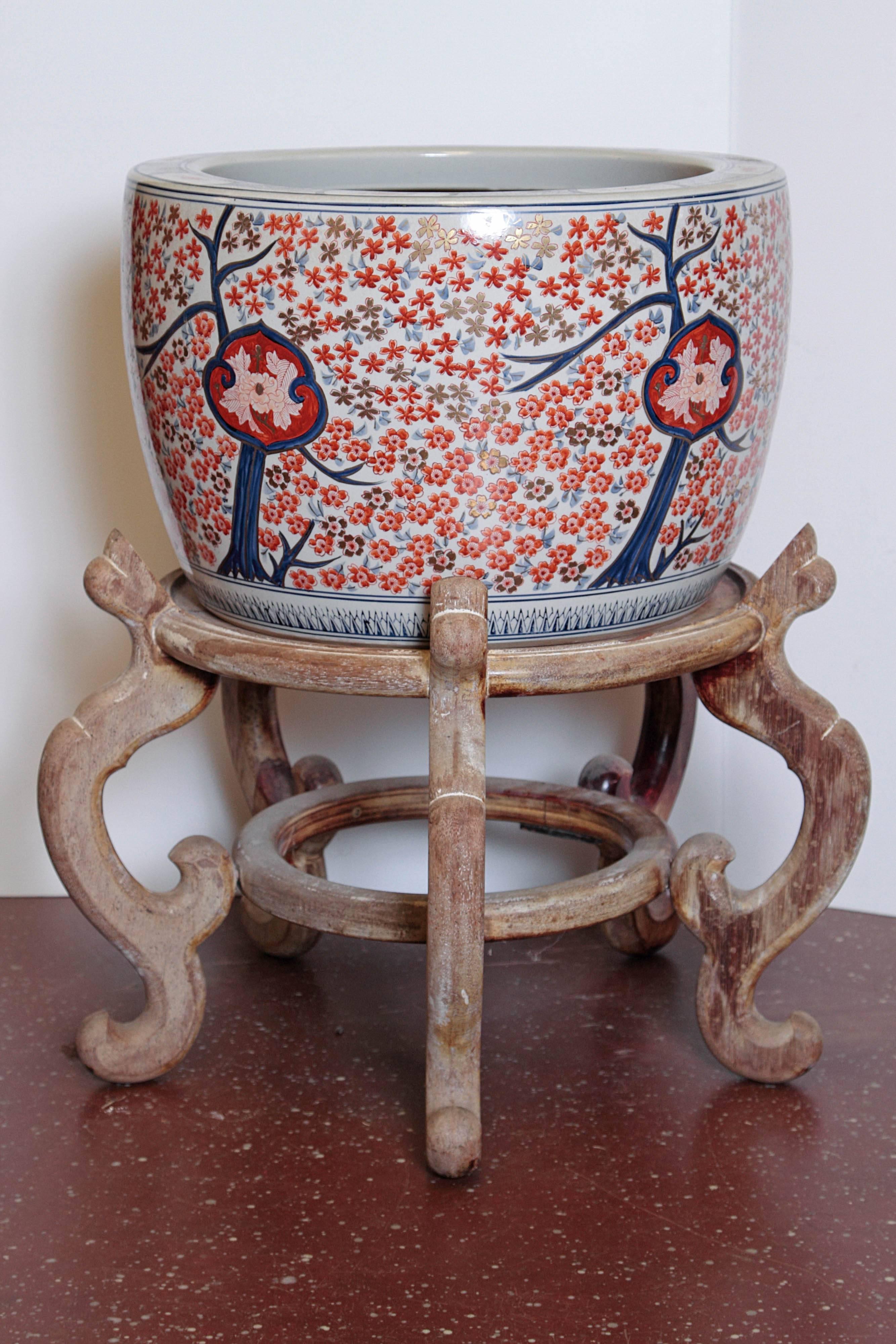 Asian planter on stand in Imari colors. Unfinished inside and drilled with three holes for drainage.