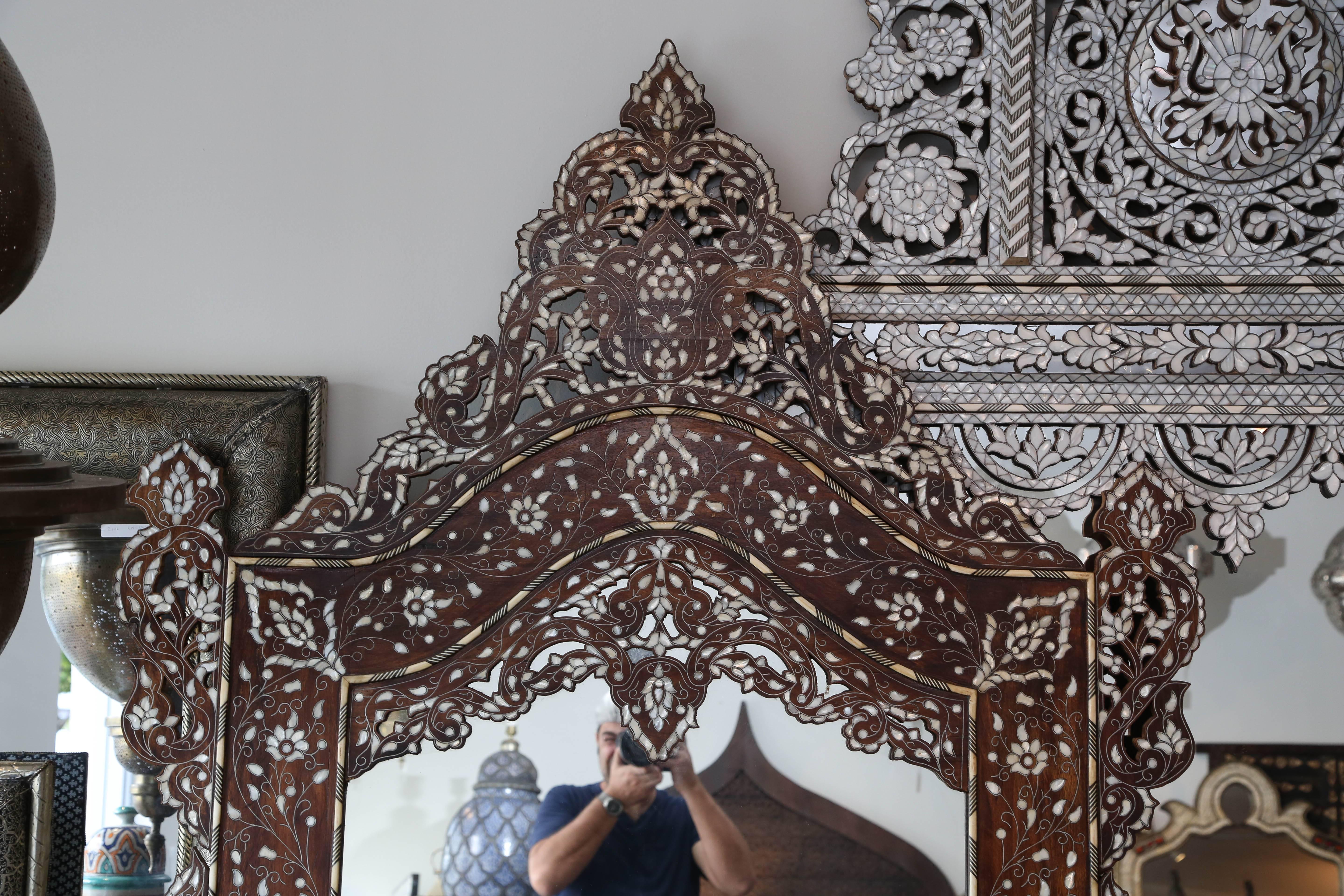 Handmade, circa 1900 antique Syrian mirror inlaid with mother-of-pearl and camel bone
 
Gorgeous walnut mirror with detachable arched top, intricately inlaid with mother-of-pearl. Delicate scroll design highlighted by thousands of pieces of