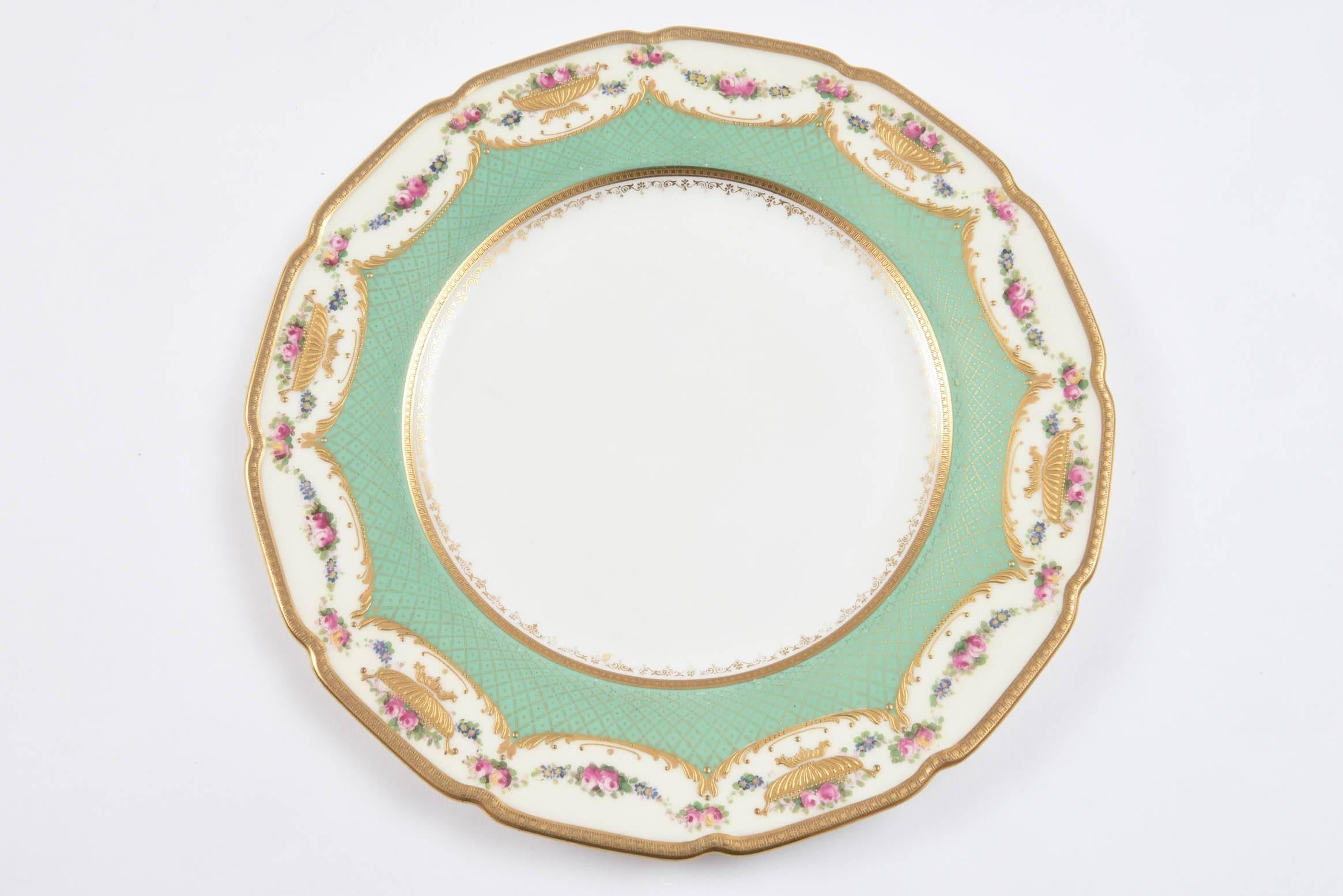 Another classic set of antique English dinner plates by Royal Doulton, England. These feature a Robert Allen designed shape and pattern. Hand-painted florals with highlights of raised tooled gilding in a shaped motif on a nice soft green collar.