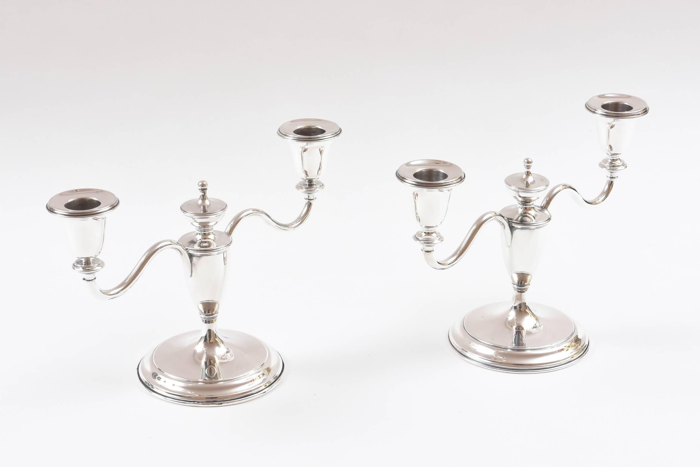 A striking pair of sterling two-arm candelabra or candlesticks by Cartier. Crisp craftsmanship featuring a classic shape and in wonderful vintage condition. Newly polished and ready for your holiday tables.