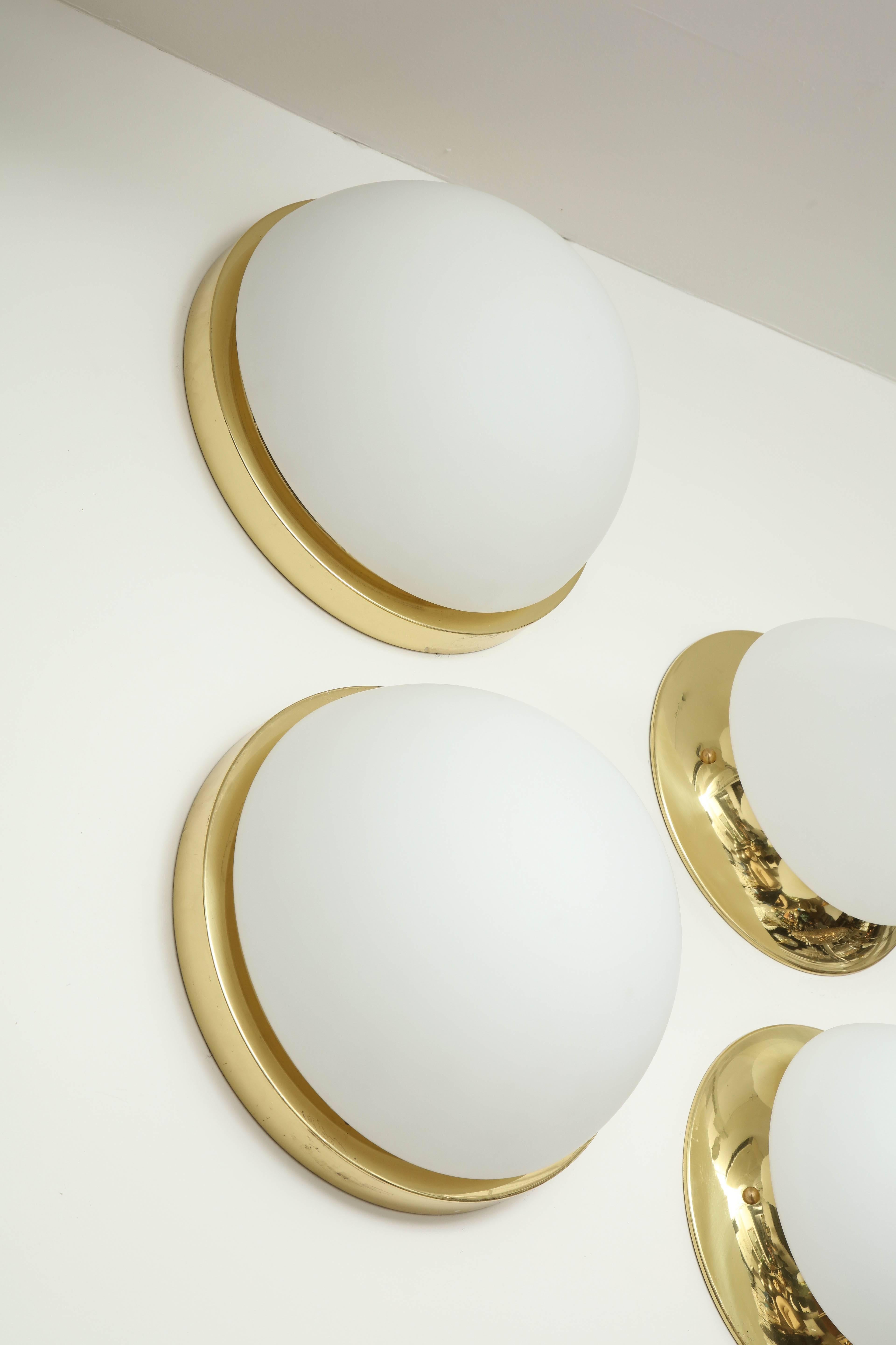 Pair of Minimalist polished brass and frosted glass flush mounts 
by Limburg.
The polished brass armature supports the frosted glass dome and is illuminated by two-light sources which have been newly rewired for the US and each socket has a 40