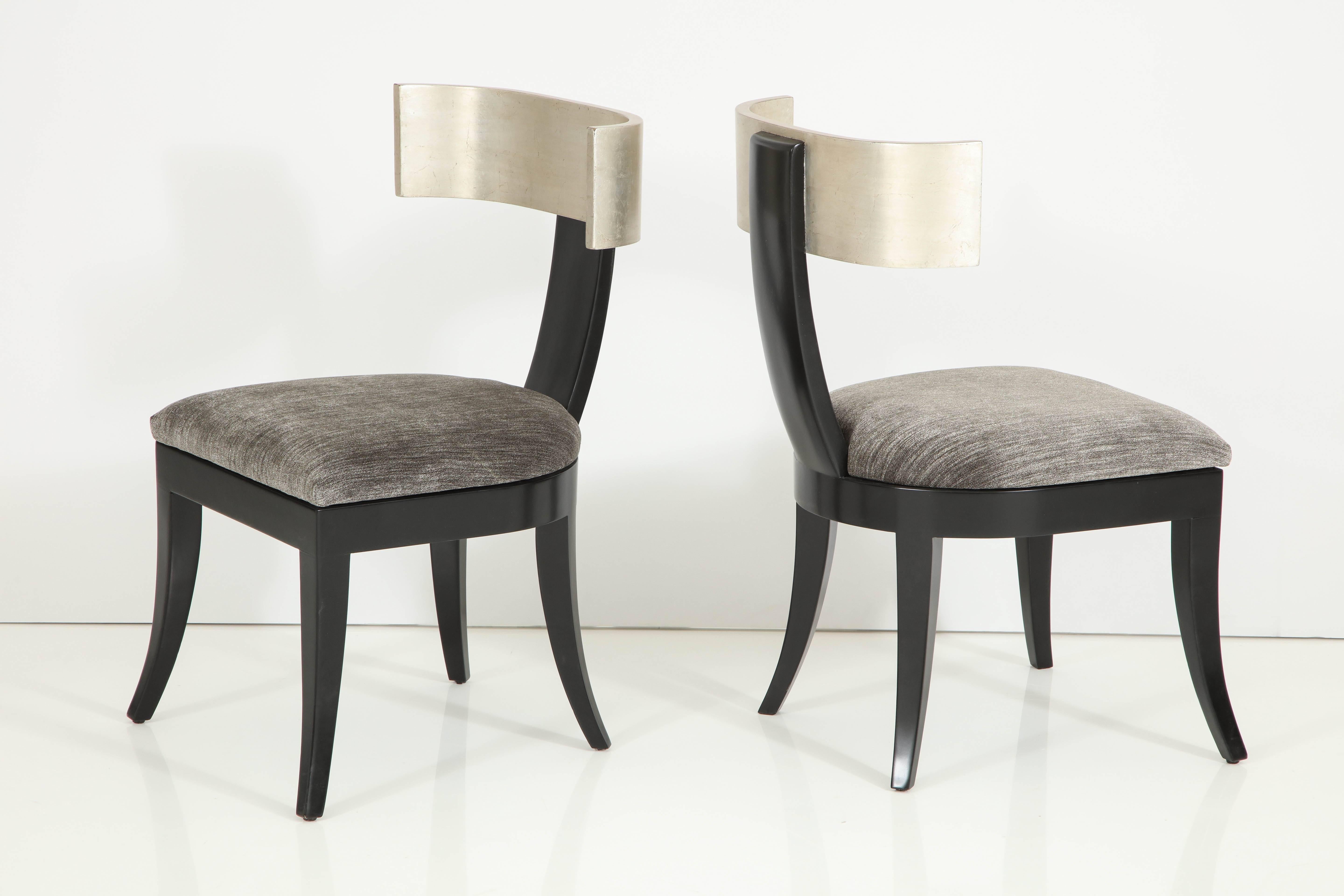 Stunning pair of Klismos chair by J Robert Scott.
These elegant chairs were a custom order and are in a satin black finish with a glazed silver leaf back.
They have been newly reupholstered in beautiful silvery gray velvet.
