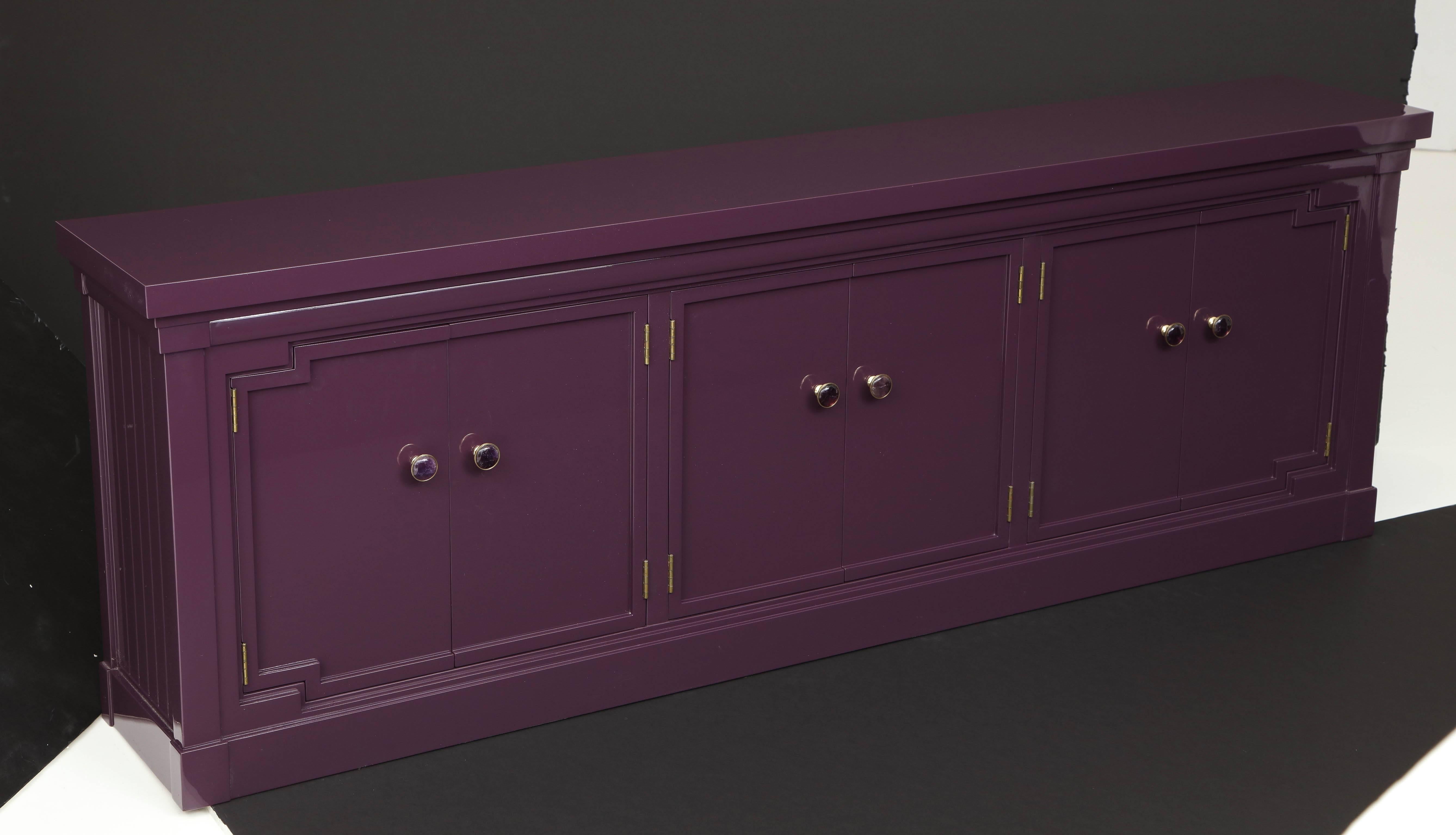 Custom refinished cabinet or console in a deep jewel tone Amethyst lacquer with brass pulls with cabochon Amethyst centers. Cabinet has three compartments, each housing an adjustable shelf.