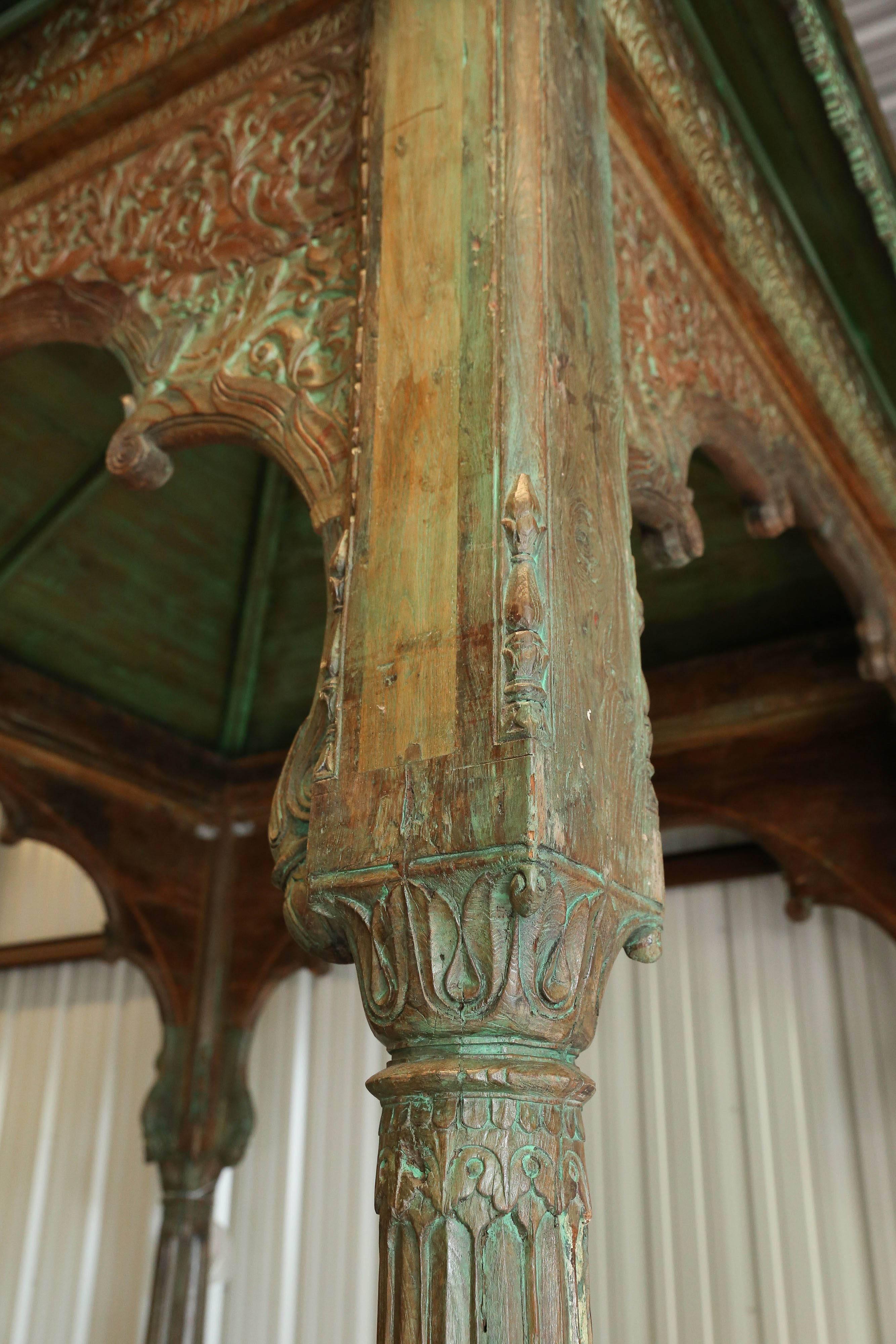 This highly carved rot resistant late 19th century Gazebo once adorned the entrance of a large village temple in central India. The four pillars that support the conical roof and the arches are tastefully carved in ethnic motif. It housed a Hindu