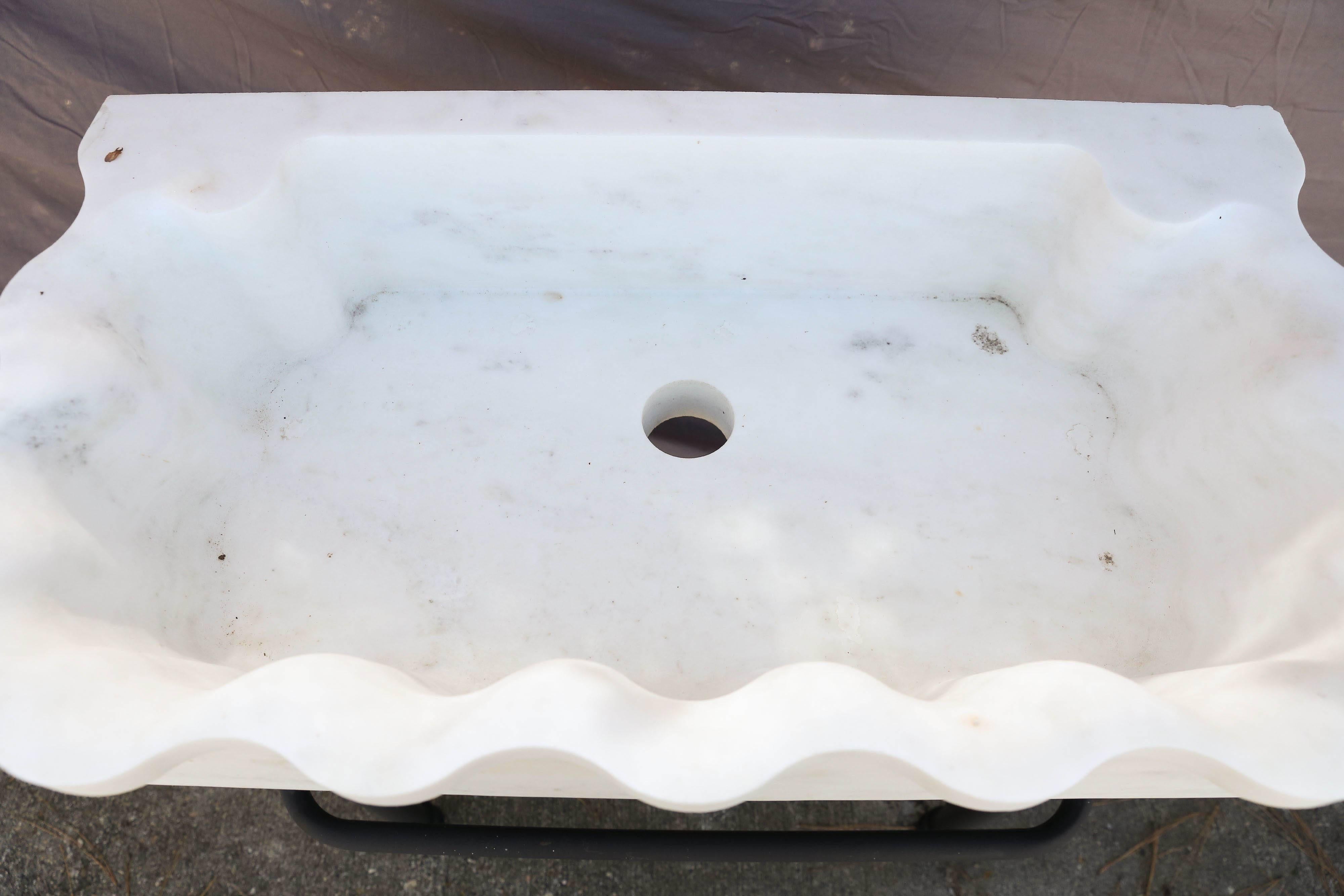 Marble sinks on iron stands were used in the open backyard of colonial homes.
The large marble sink is hand-carved from one block of large fine quality marble slab. The support is made of iron and has a towel rack. It is solid and will last several
