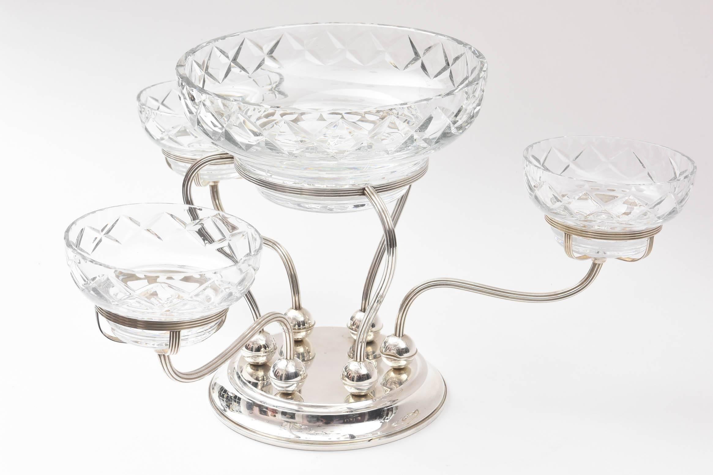 An elegant centrepiece from one of America's storied silversmith's: Gorham. This classic piece features cut crystal bowls which nestle on top of hand chased metal arms. An unique base supports the epergne and comes apart for easy polishing and