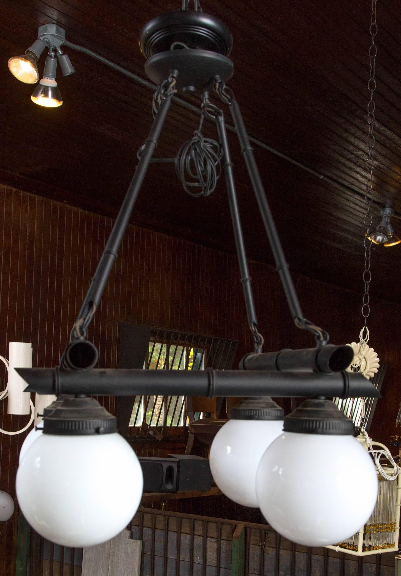 Very stylish and unusual chinoiserie, black metal faux bamboo 
chandelier. Square horizontal faux bamboo framework with four suspended milk glass globes at each corner.
