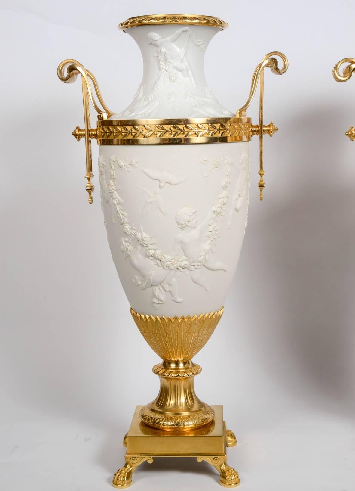 Gorgeous vases white bisquit standing on a gilded bronze base, with two gilded bronze handles.