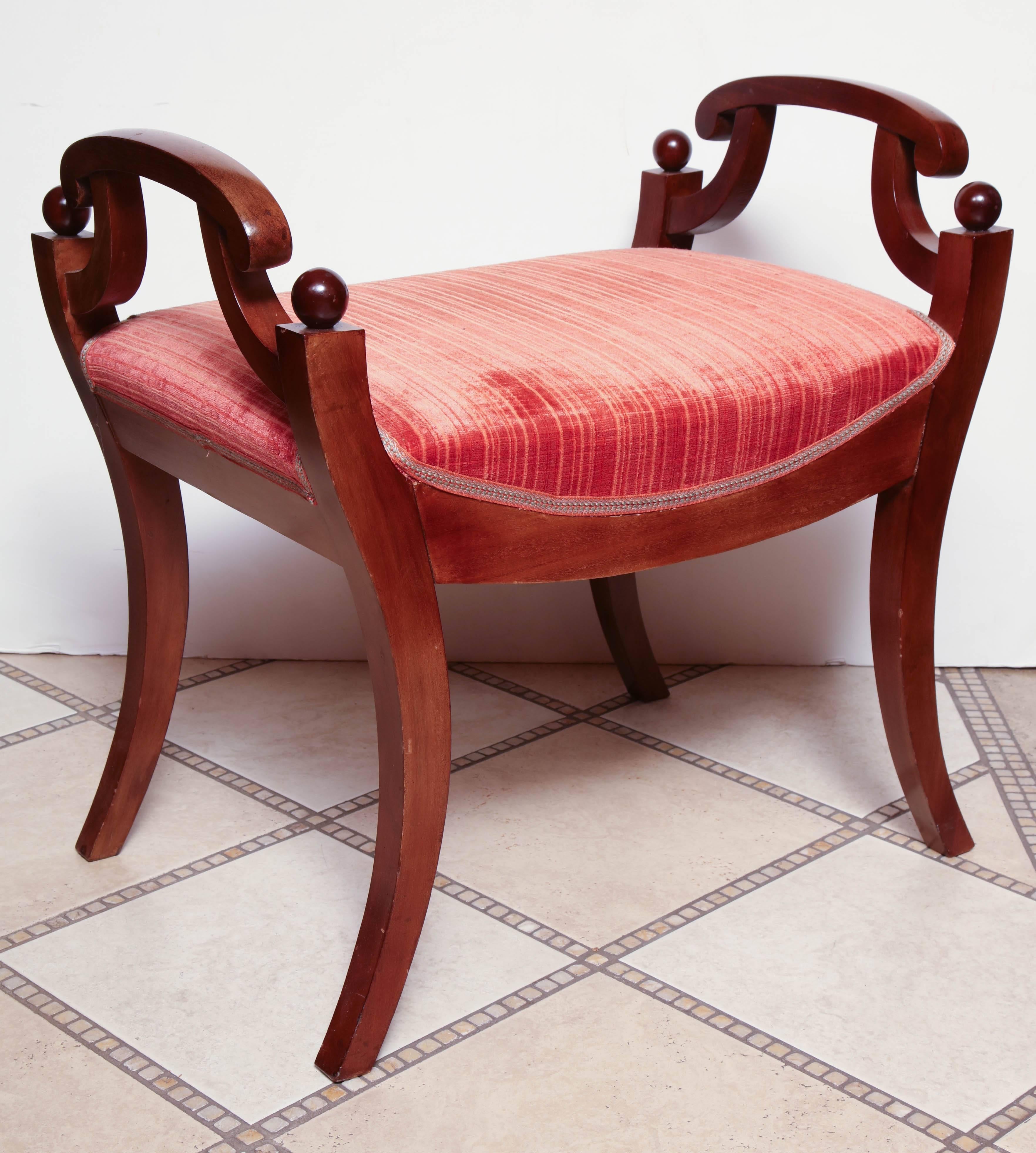 Pair of Neo Classic Mahogany stools with upholstered saddle seat and out-flaring legs.