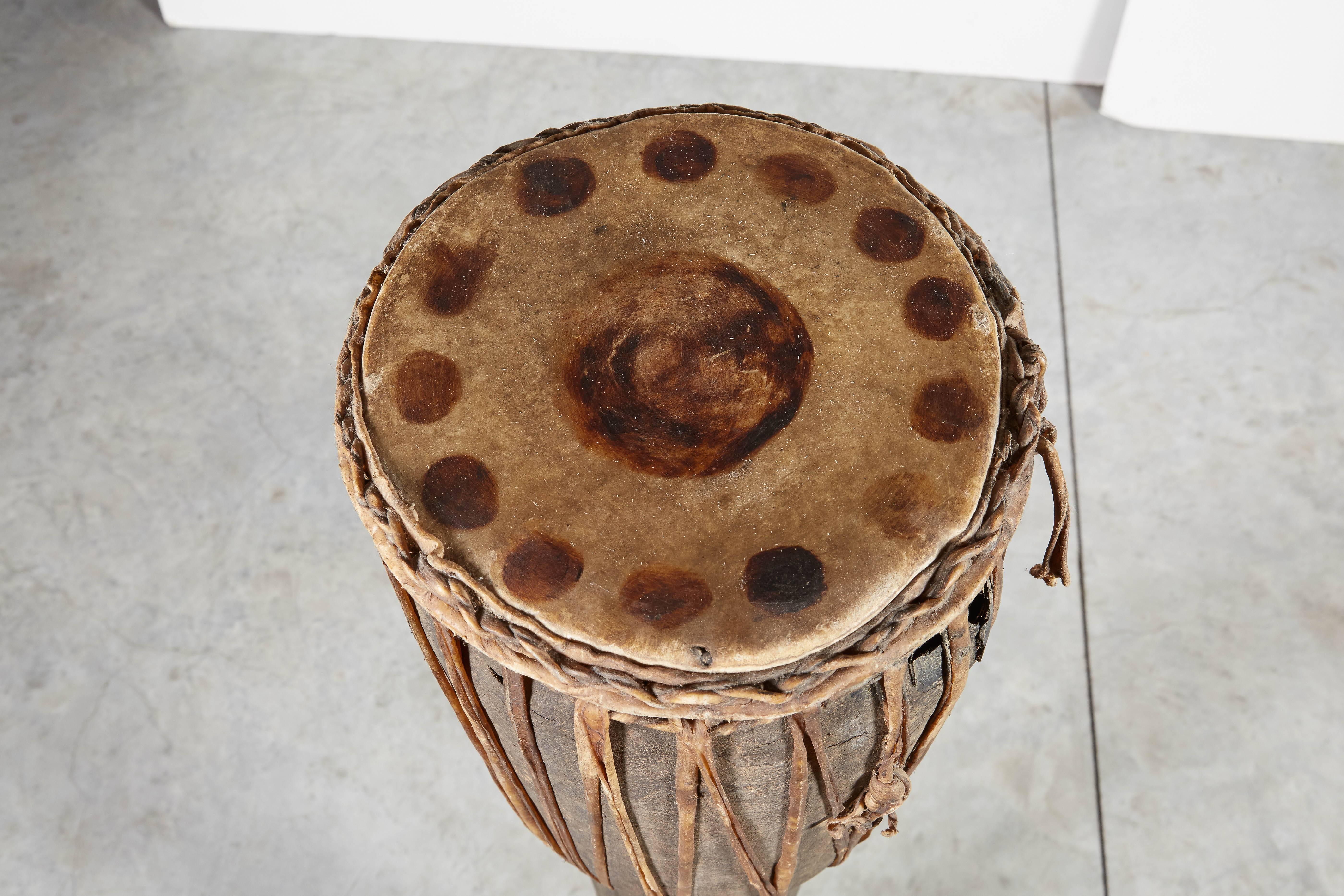 A  magnifique tambour de 48 pouces de haut provenant des tribus des collines à la frontière de la Thaïlande et de la Birmanie, avec des sangles en cuir et un dessus en cuir tacheté d'origine. Une pièce avec beaucoup de présence et